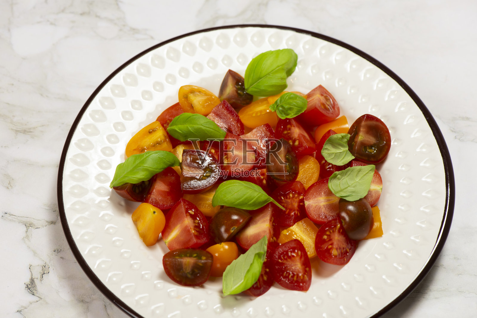 带有罗勒的红色和黄色樱桃番茄沙拉照片摄影图片