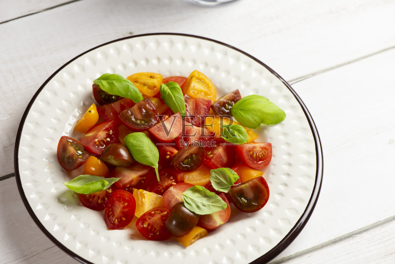 带有罗勒的红色和黄色樱桃番茄沙拉照片摄影图片