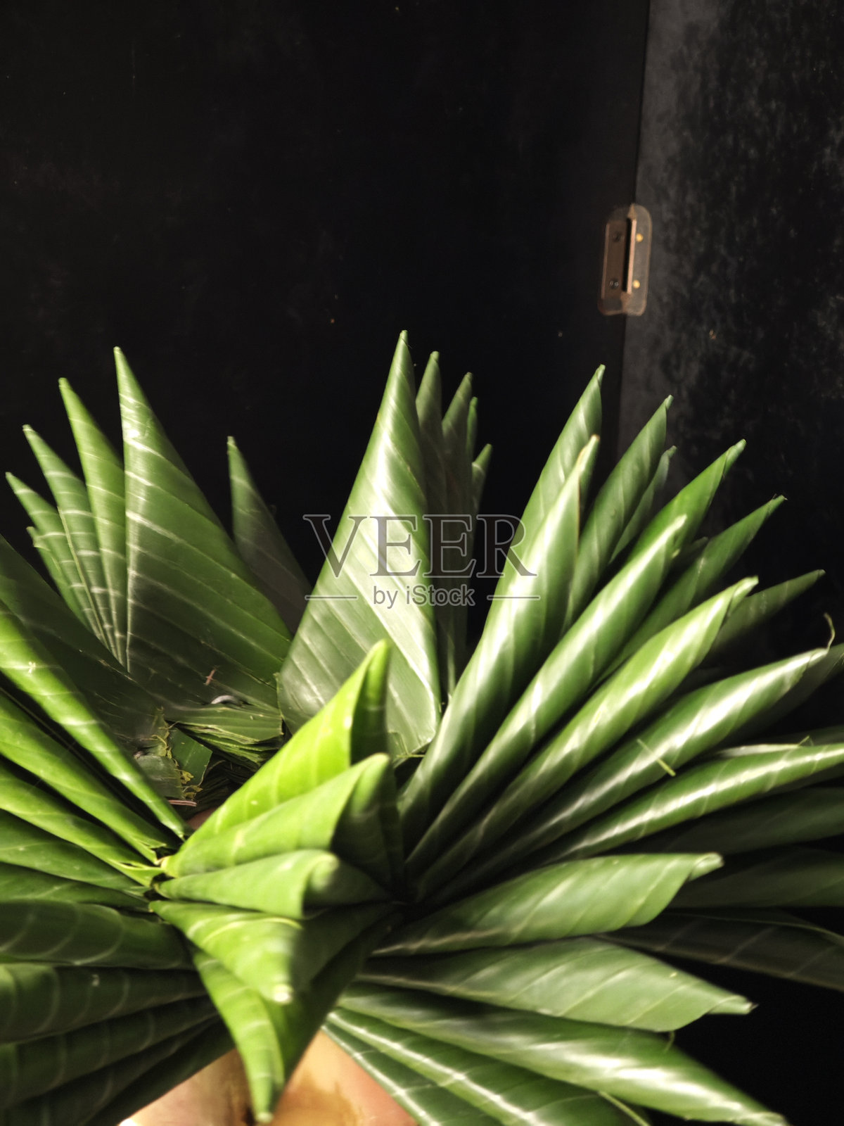 “幕后花絮：泰国传统水灯制作” 描述：抓拍女性在安静的氛围中整理花朵和叶子的背影，展现水灯制作的冥想过程。照片摄影图片