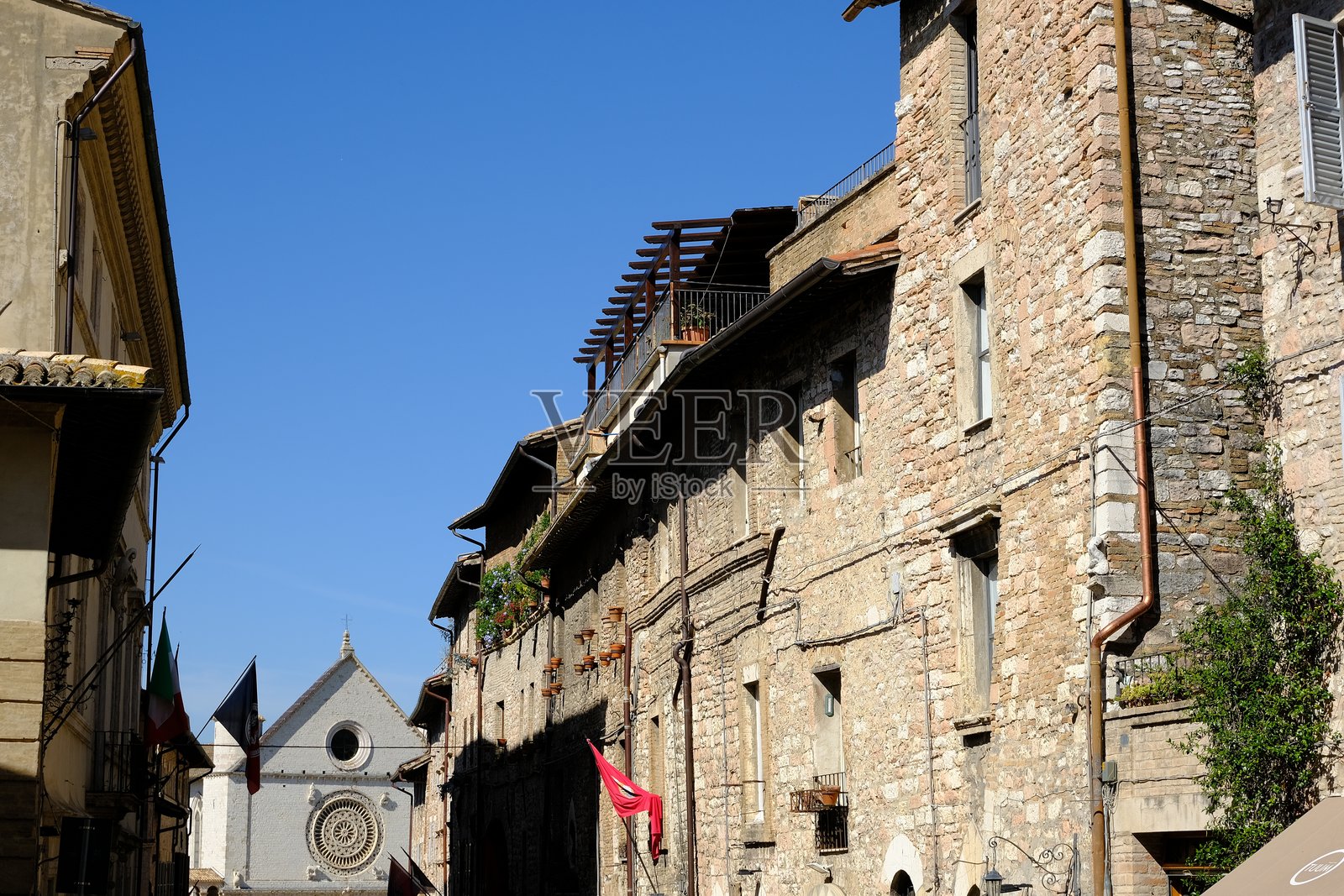 历史悠久的圣方济各街通往著名的圣方济各大教堂。石砖房屋的外立面上飘扬着旗帜。照片摄影图片