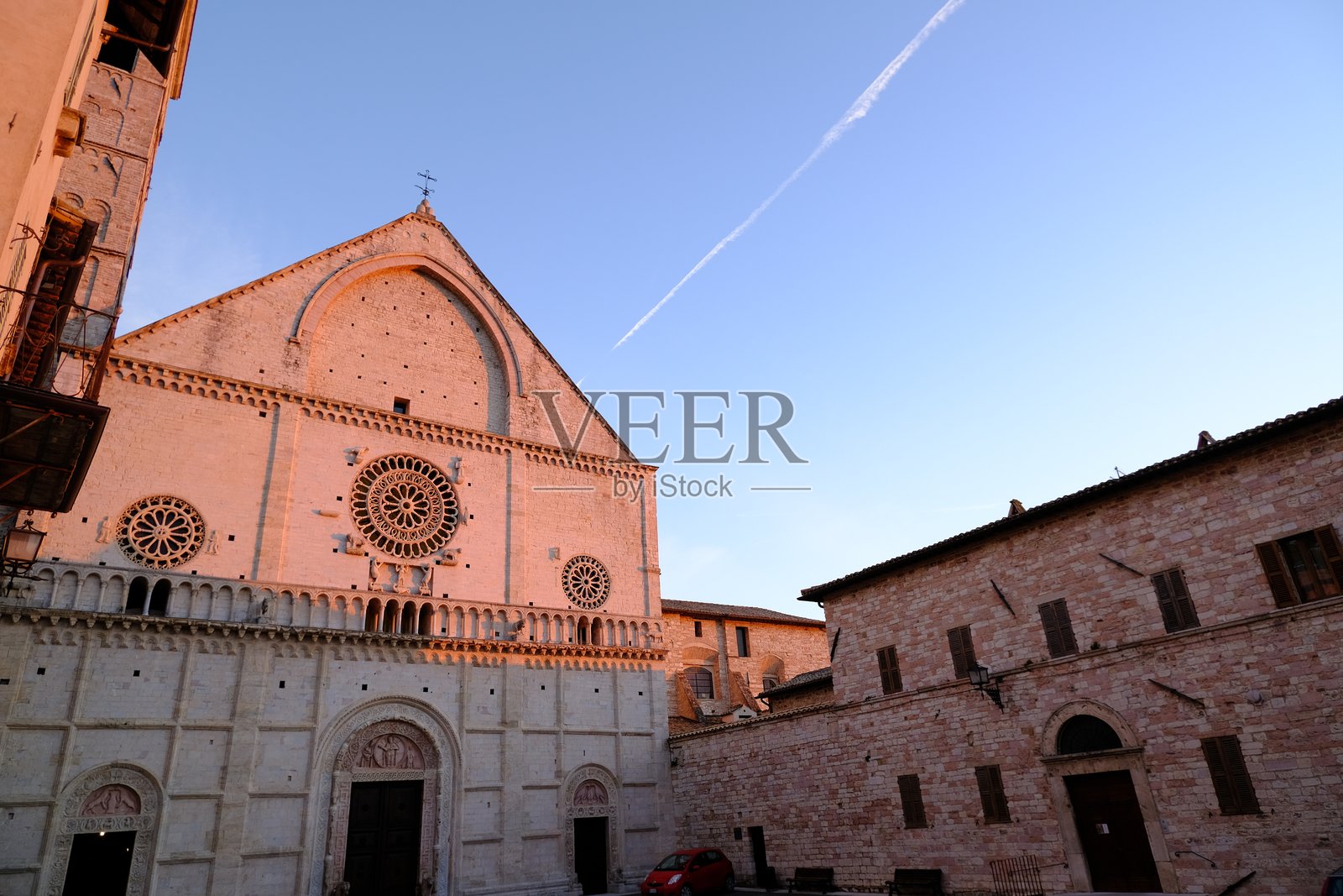 阿西西的圣鲁菲诺大教堂,石制外立面,三角楣上的尖拱。日落时分拍摄,光线柔和。照片摄影图片