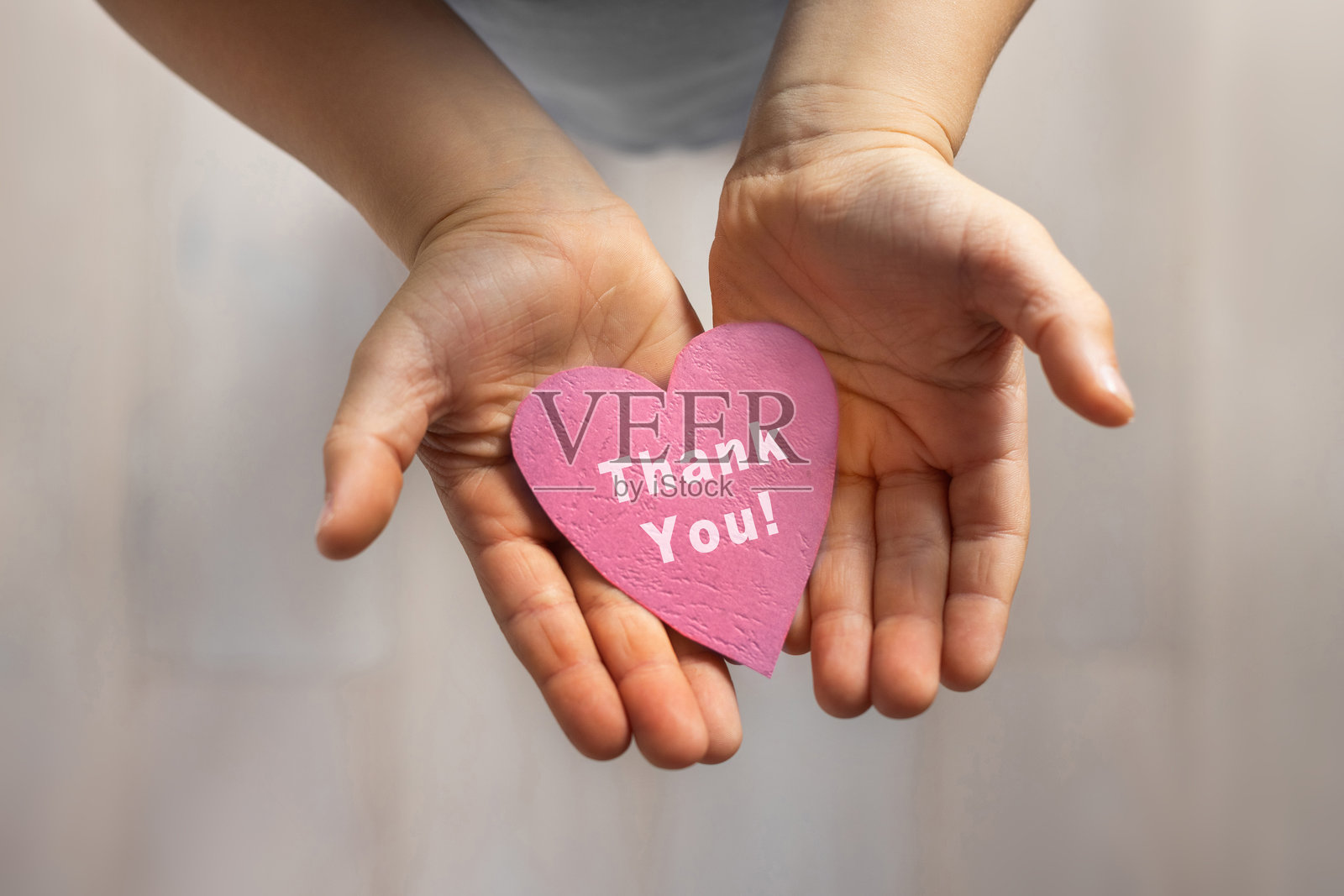 感谢卡，感恩概念，孩子的手握着粉色纸心，上面写着感谢的信息照片摄影图片