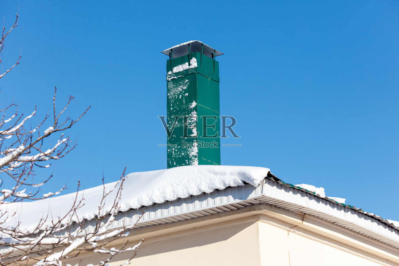 一个覆盖着雪的绿色烟囱照片摄影图片