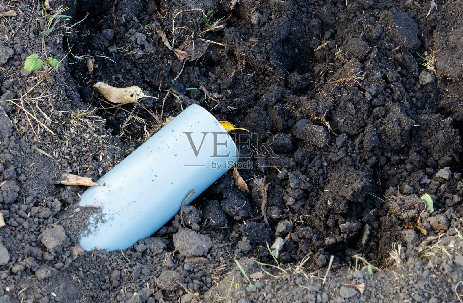 一根管道躺在泥土中照片摄影图片