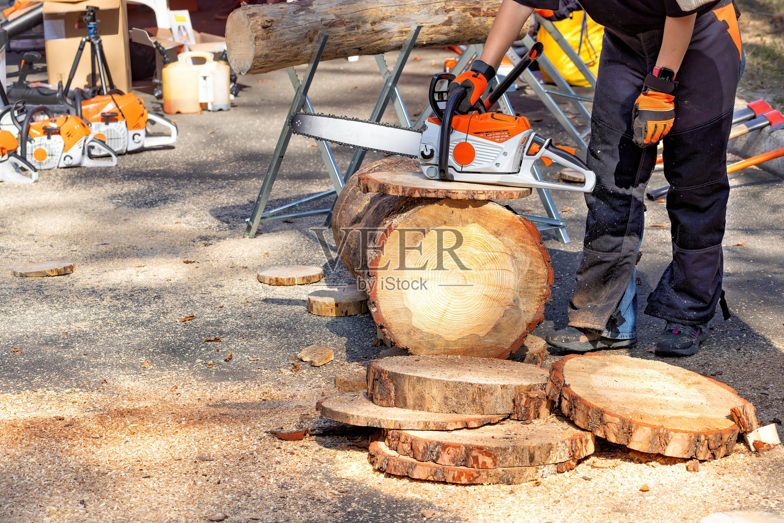 在阳光明媚的日子里，使用电锯在户外制作木片照片摄影图片