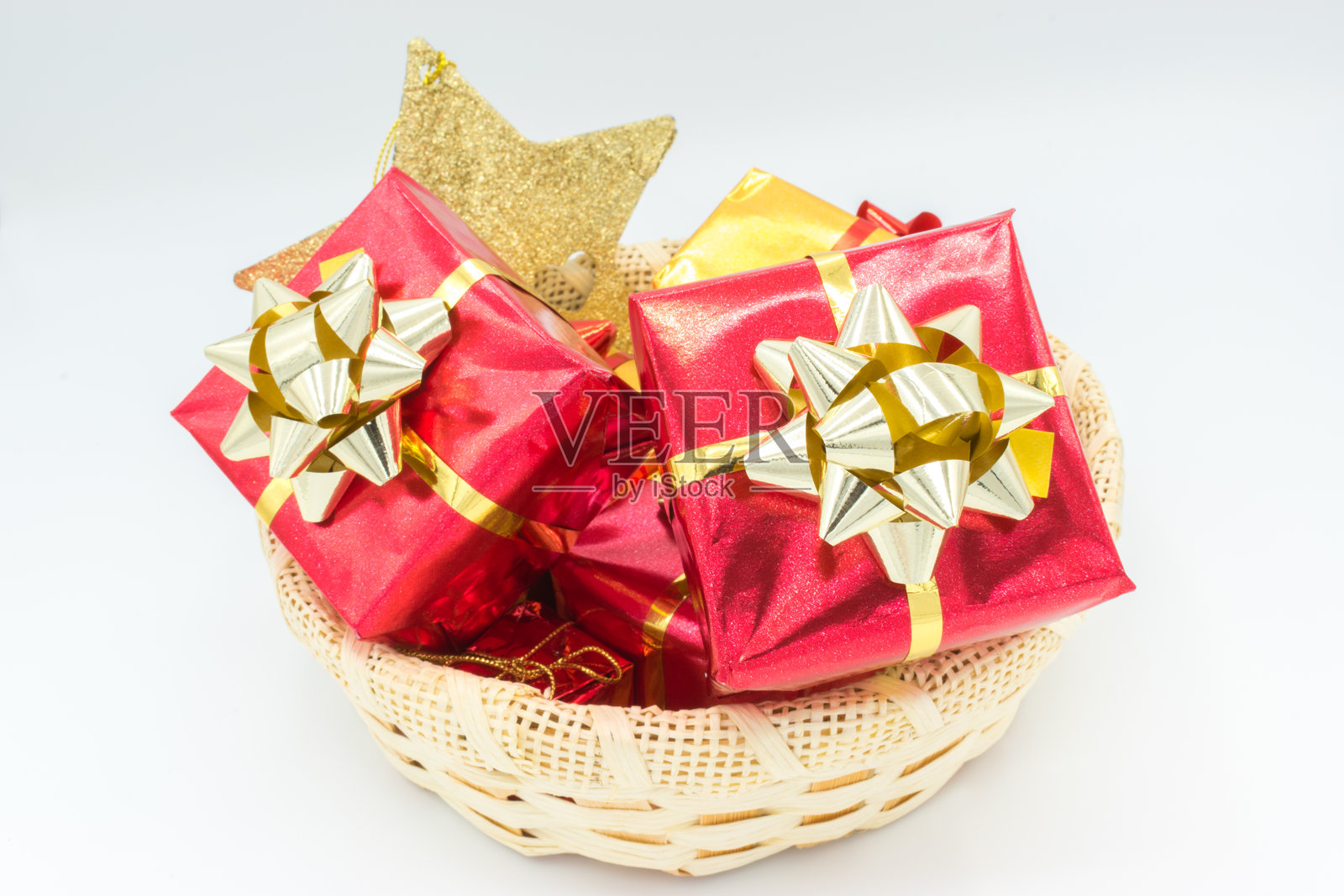 装饰有丝带和金色星星的藤编篮子，里面放着礼物。照片摄影图片