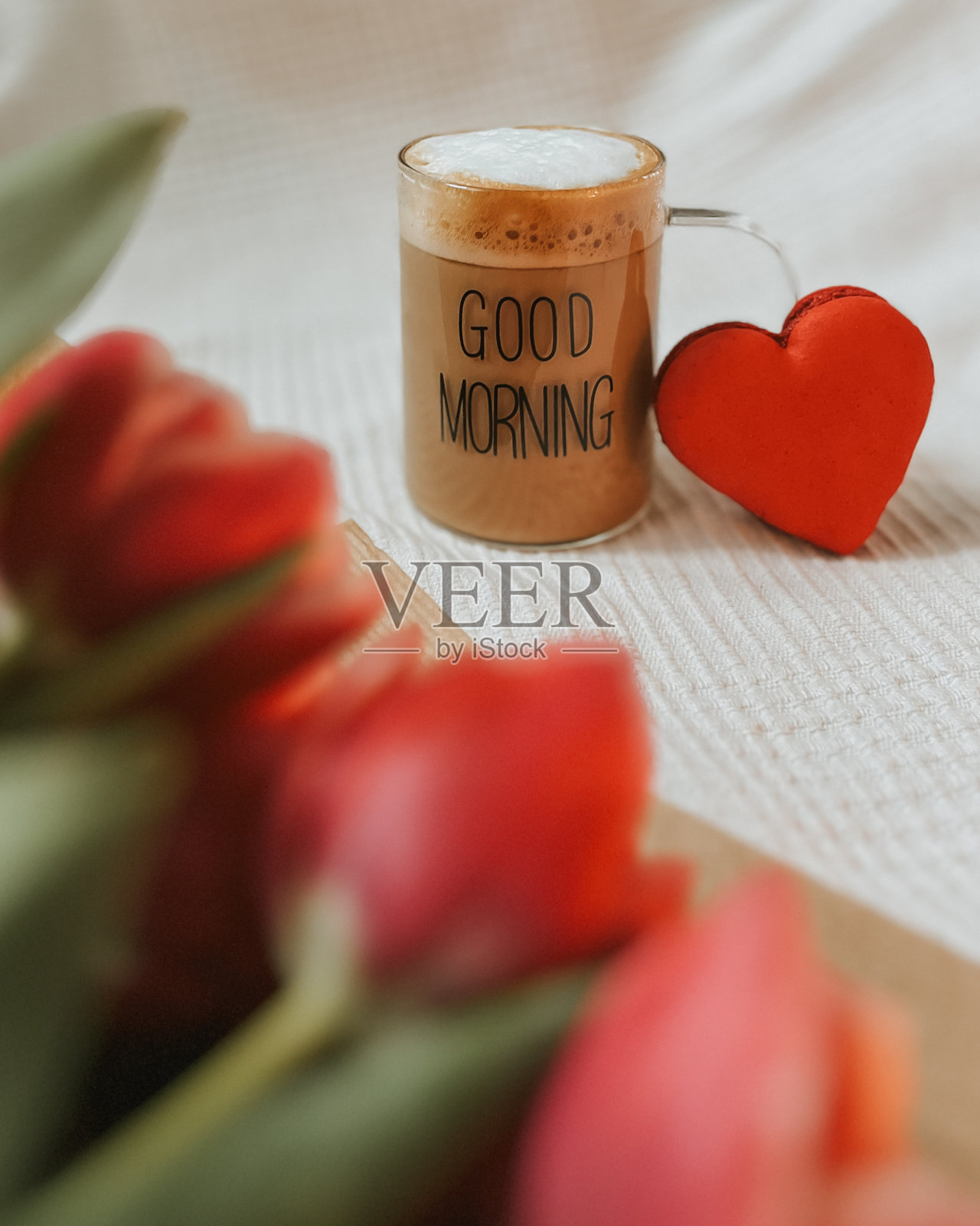 卡布奇诺、红色心形马卡龙和一束红色郁金香照片摄影图片