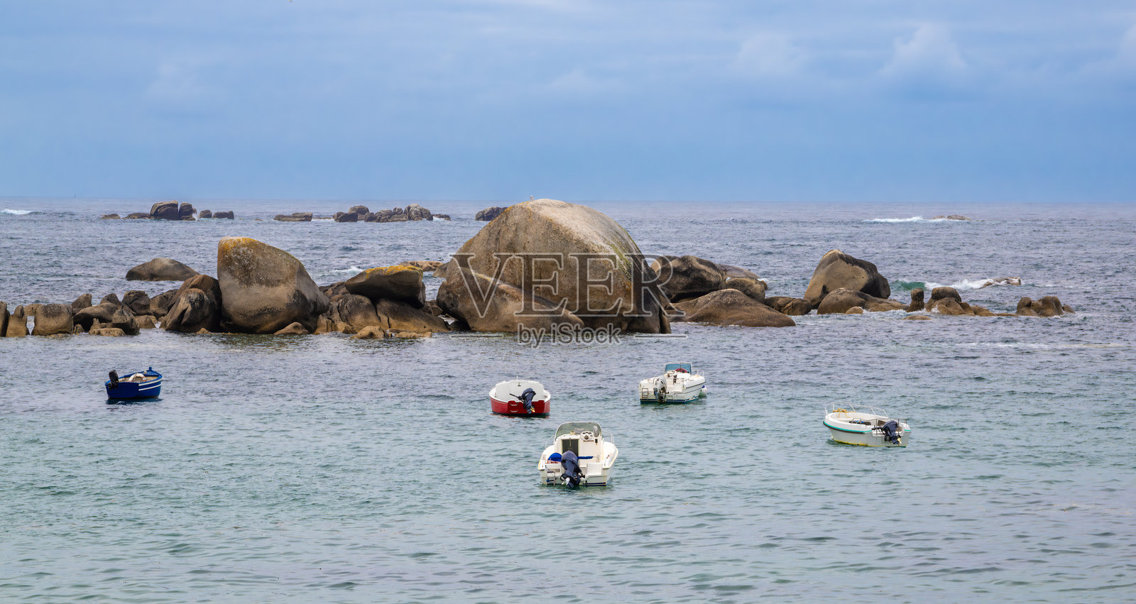 布列塔尼岩石海岸附近停泊的船只照片摄影图片