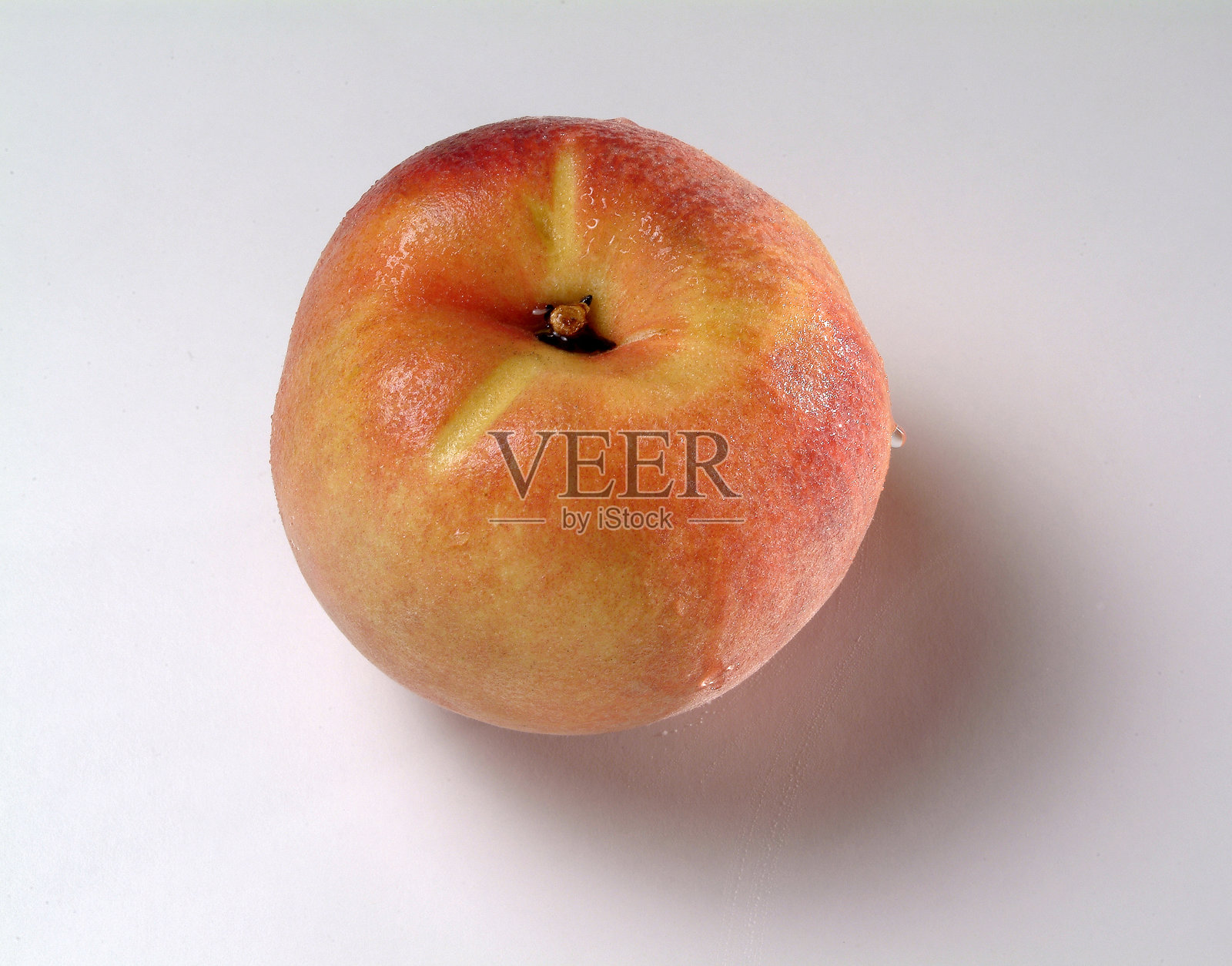 静物画：一只橙色的桃子，背景为中性色调照片摄影图片