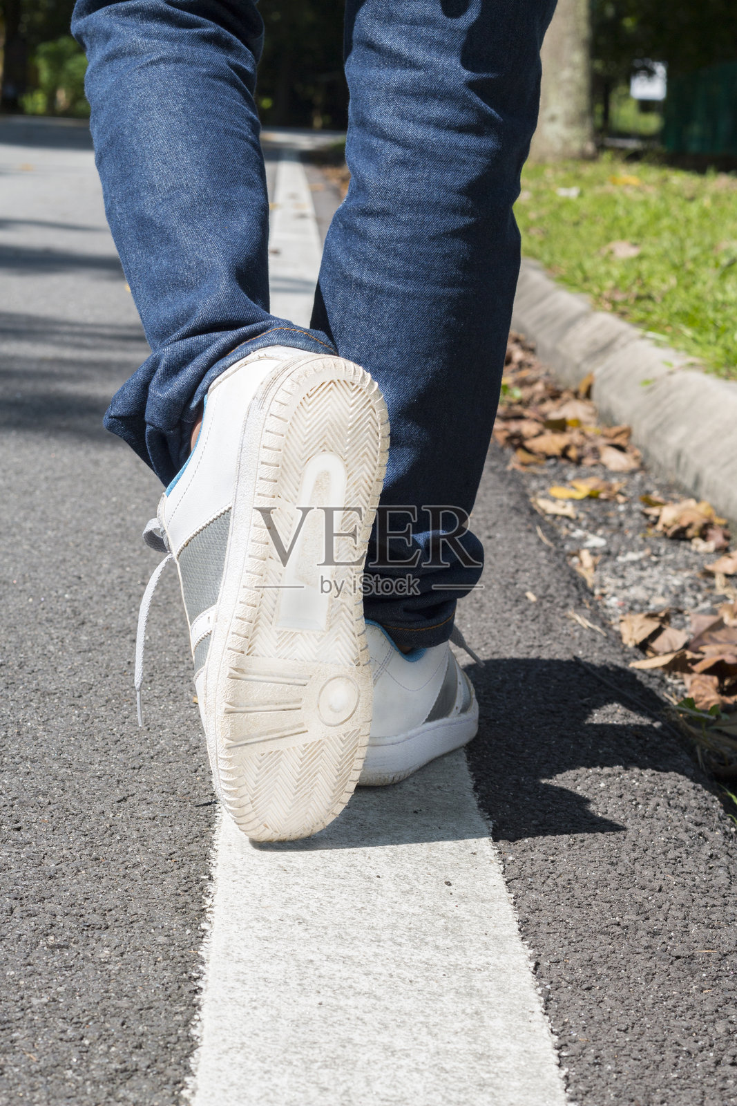 阳光明媚的日子里，男人走在路标上。照片摄影图片