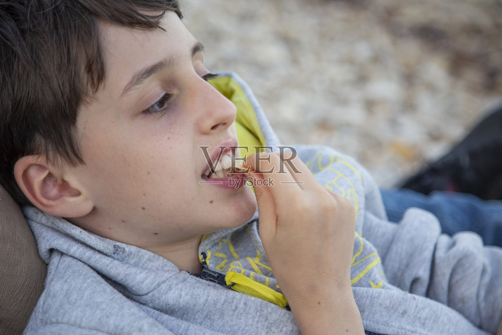 一个男孩在海边吃薯片照片摄影图片