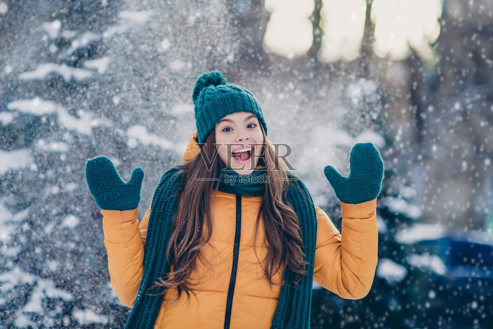 可爱的、惊讶的小女孩穿着风衣，享受乡村森林中的雪天。照片摄影图片
