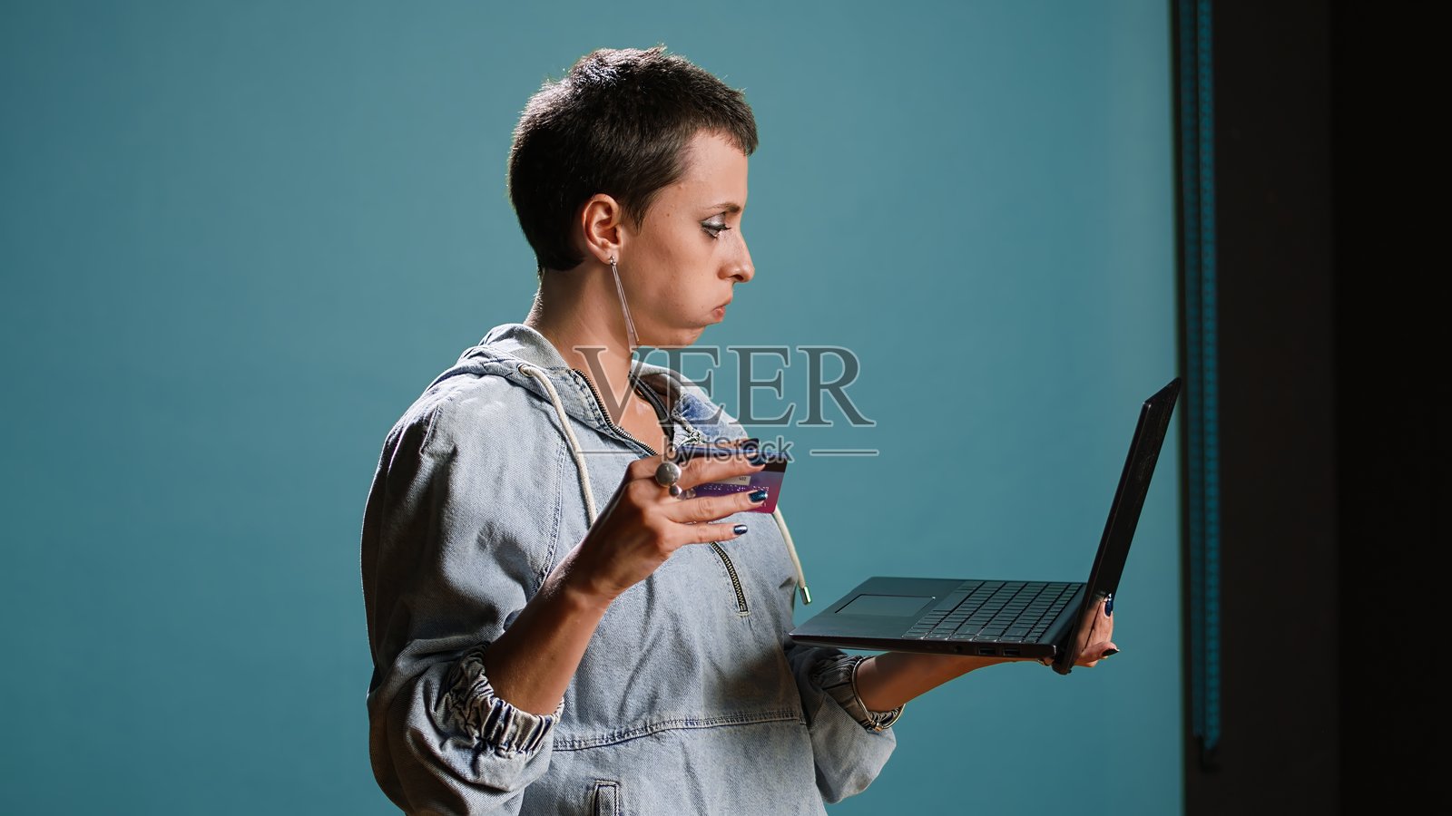 年轻女性在商店网站上下单并花钱购买衣服照片摄影图片