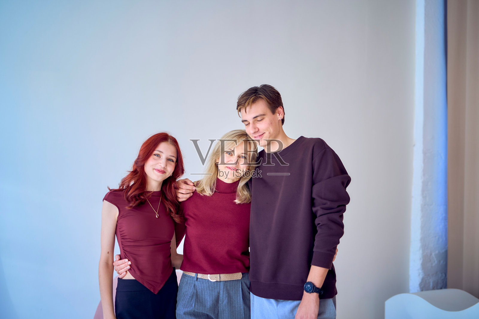 一位中年母亲拥抱着她的成年儿子和青少年女儿照片摄影图片