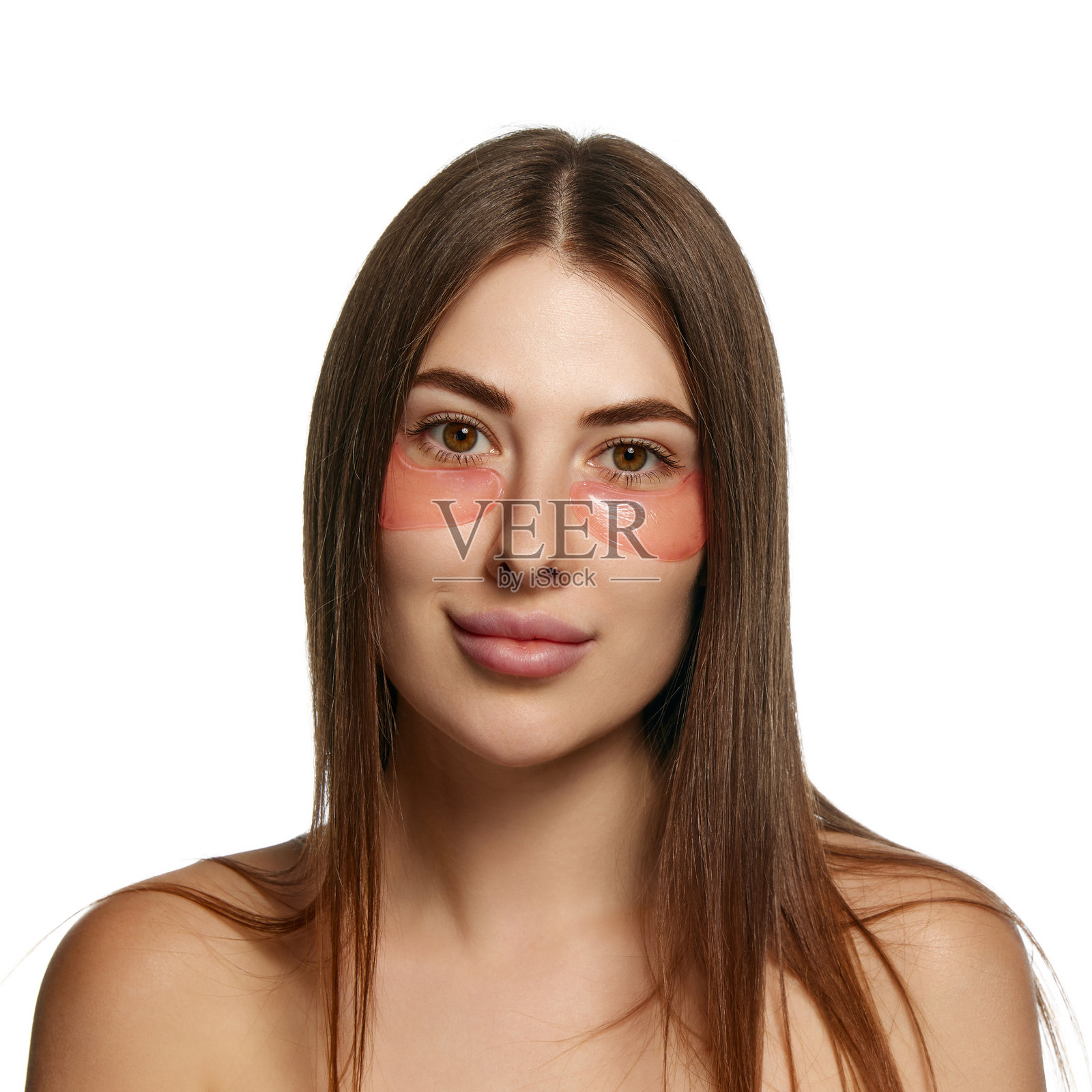 面带微笑的女性肖像，注视着镜头，眼下贴着眼膜，背景为白色。照片摄影图片