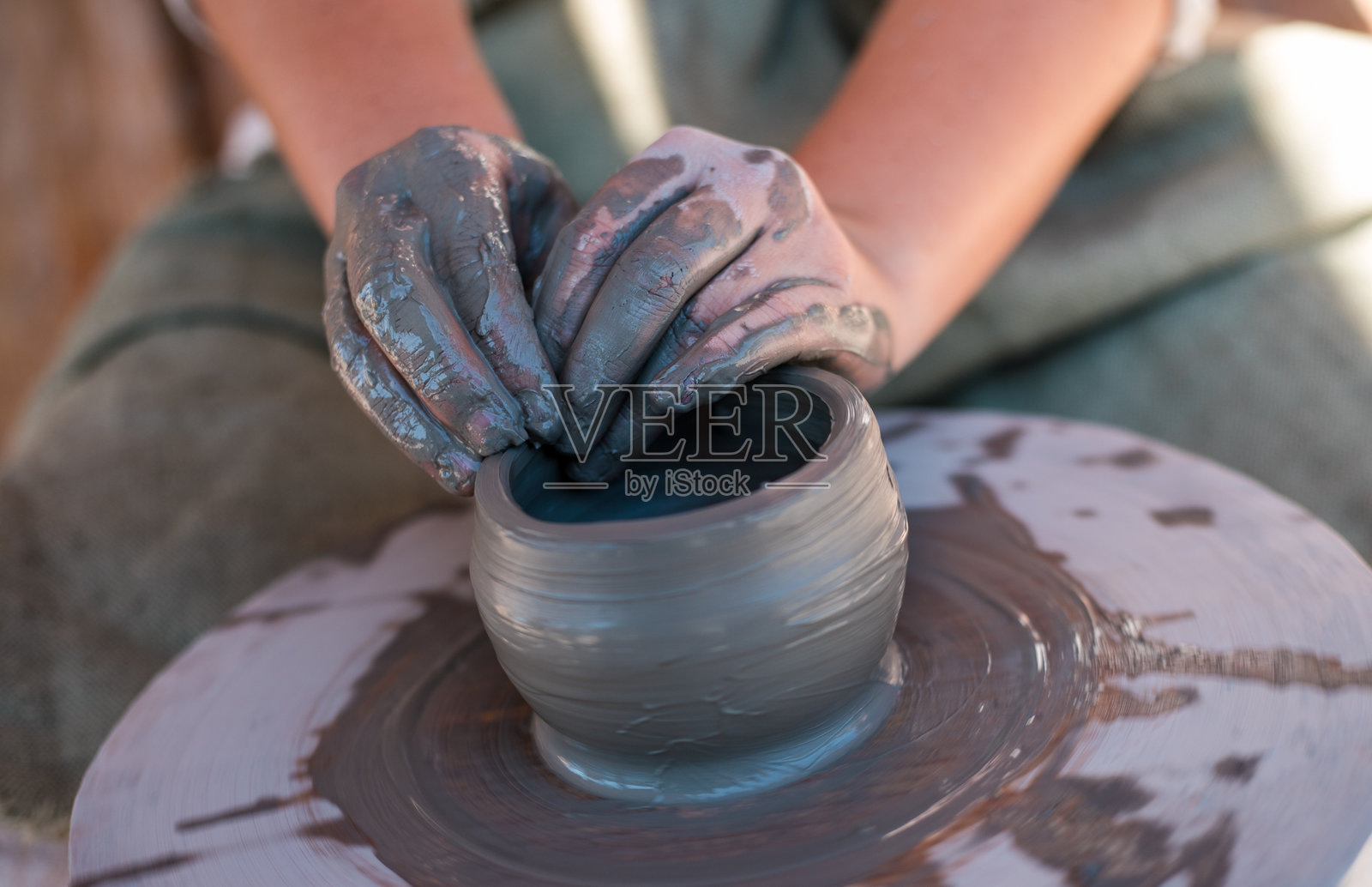 陶艺师正在陶轮上制作陶器。照片摄影图片