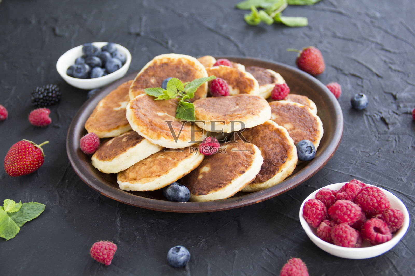 健康的早餐：奶酪煎饼、浆果和蜂蜜。照片摄影图片