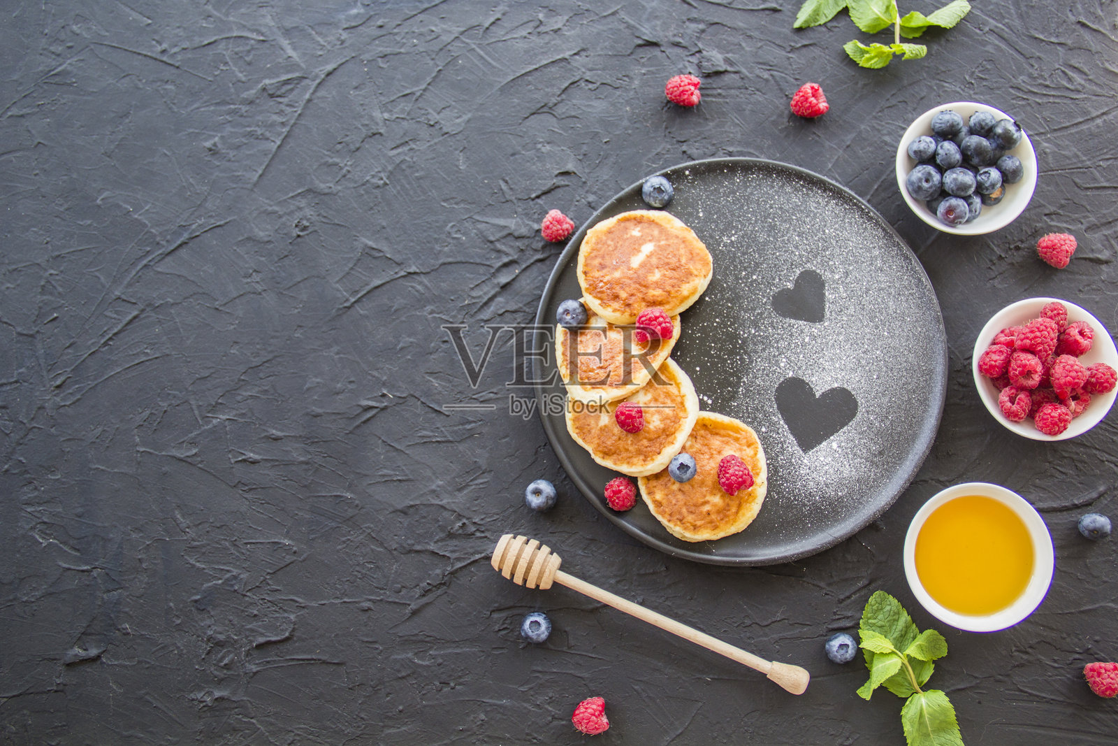 健康的早餐：奶酪煎饼、浆果和蜂蜜。照片摄影图片