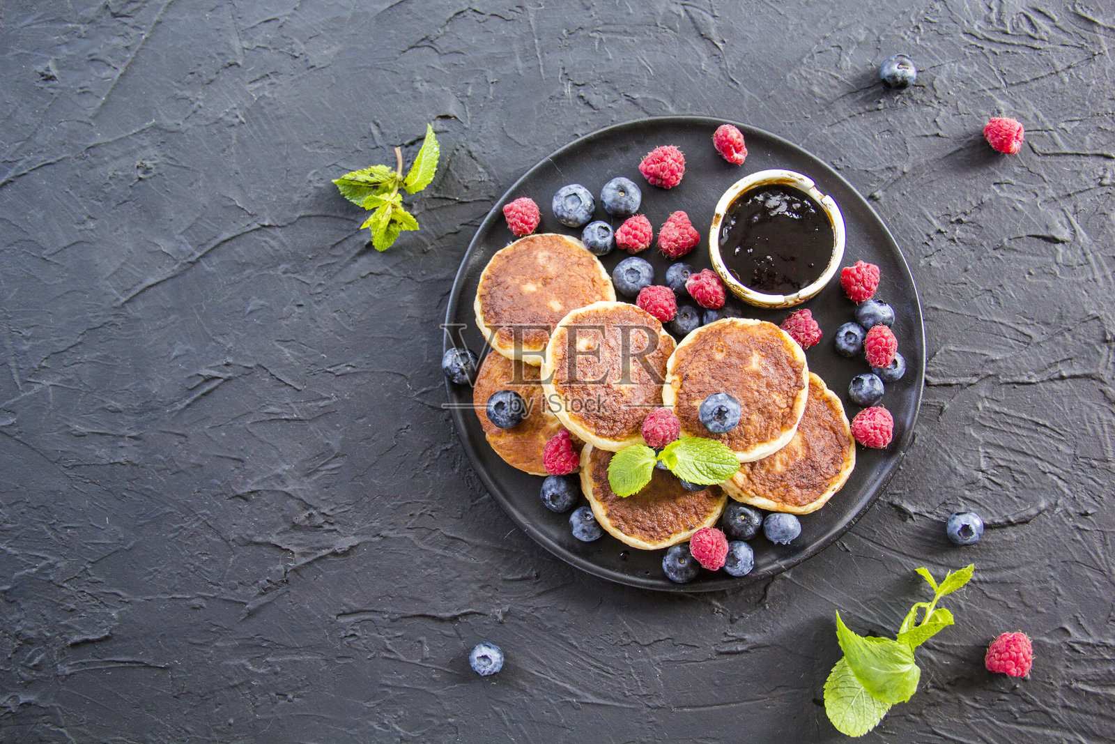 健康的早餐：奶酪煎饼、浆果和蜂蜜。照片摄影图片