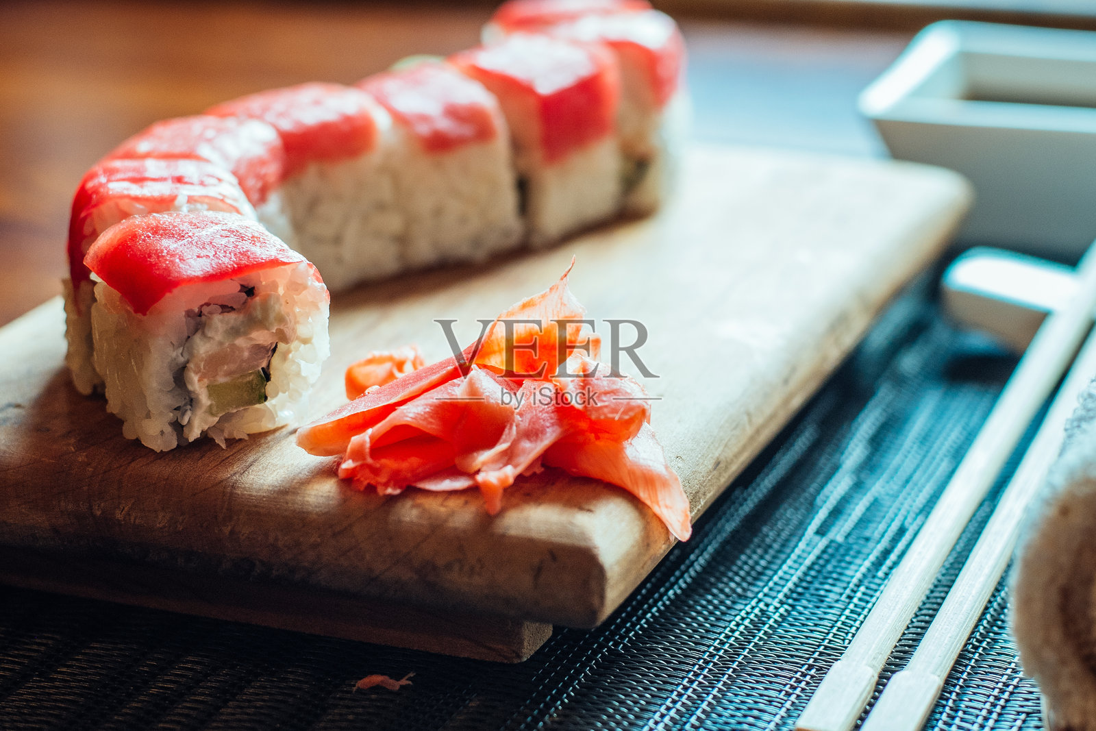 一卷红肉和绿色蔬菜的寿司放在木板上照片摄影图片