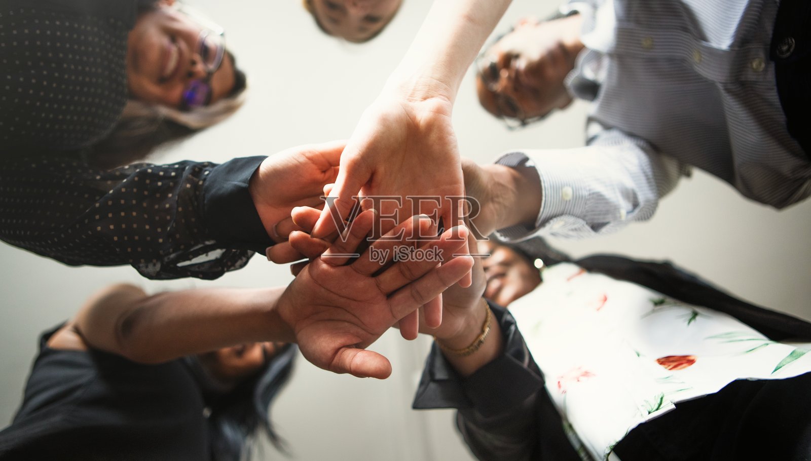 多元化女性团队的手叠在一起。照片摄影图片