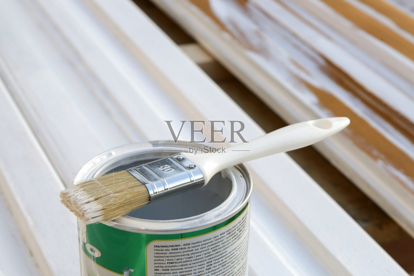 木质背景上的白色油漆桶和刷子照片摄影图片