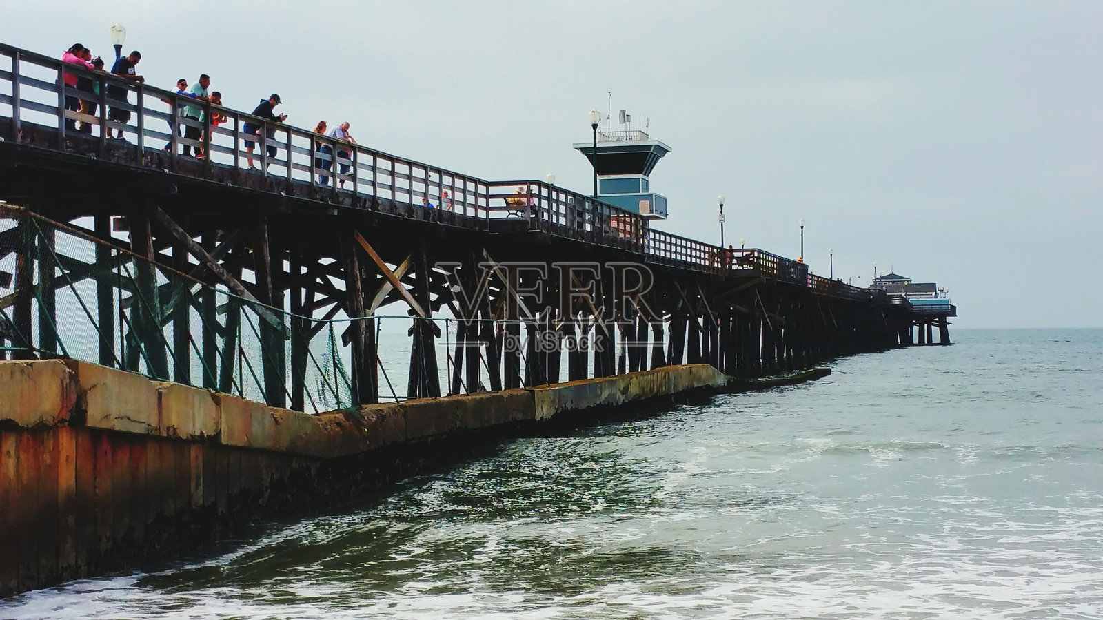 人们在海上码头上与天空相对照片摄影图片