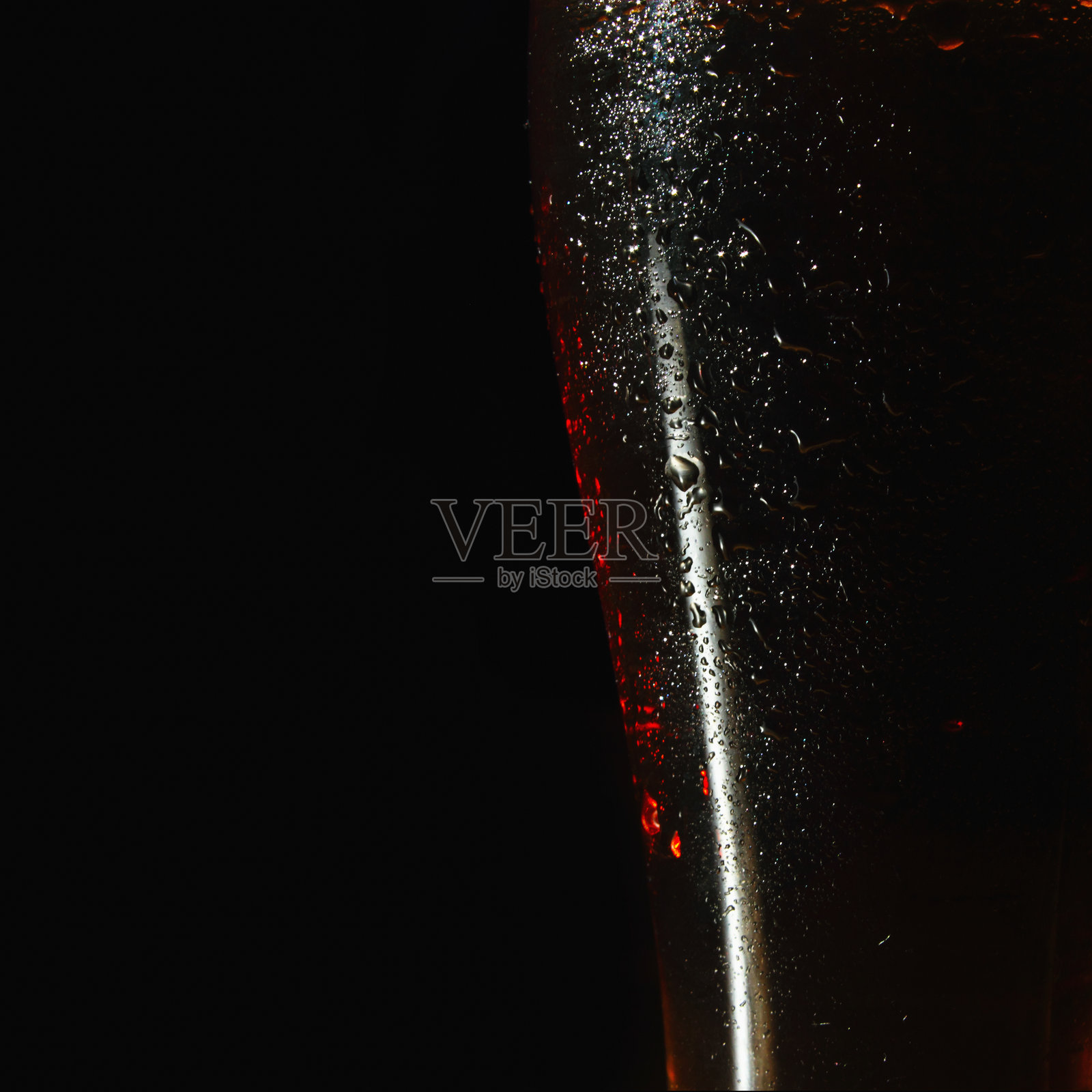 黑色背景下的深色啤酒杯特写。设计留白。照片摄影图片