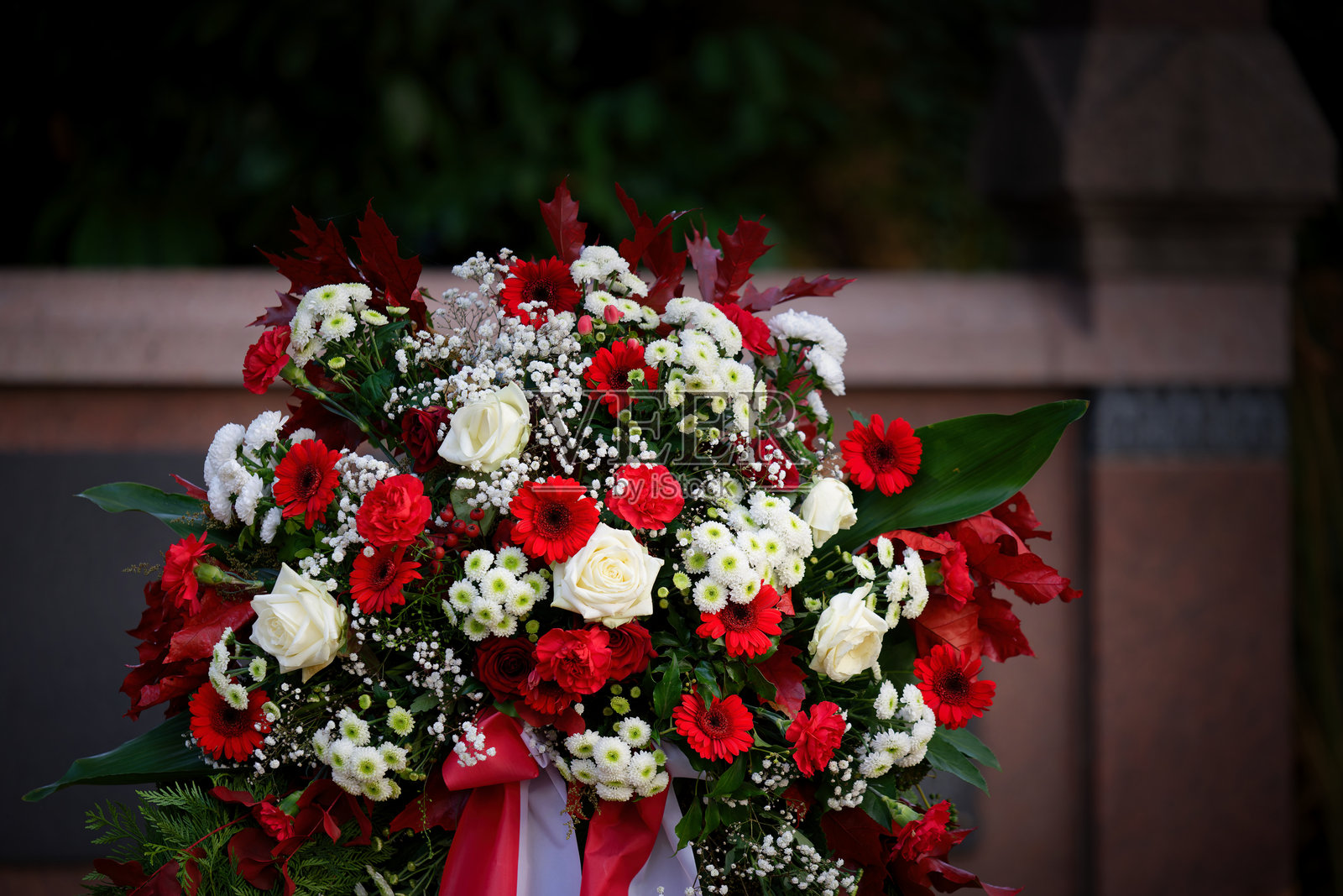 红白相间的葬礼花卉布置在墓地上照片摄影图片