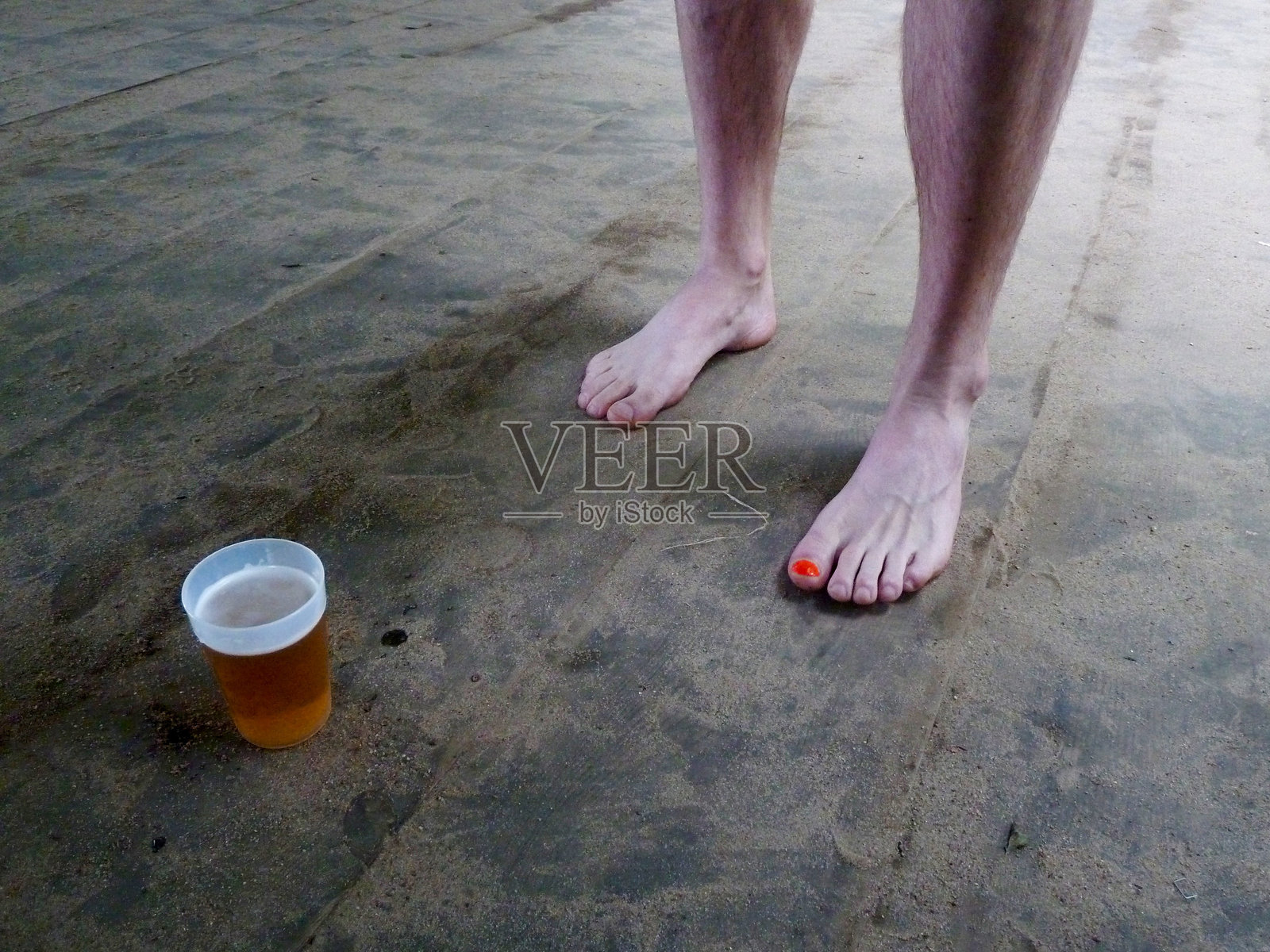 男人站在木地板上，旁边放着饮料的下半身照片摄影图片