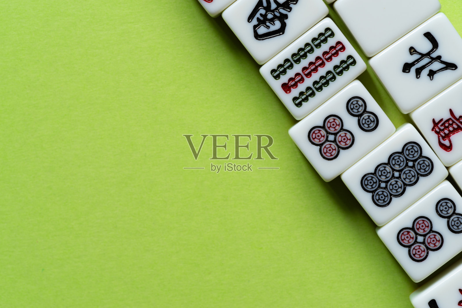 麻将牌排成一行，背景为绿色照片摄影图片