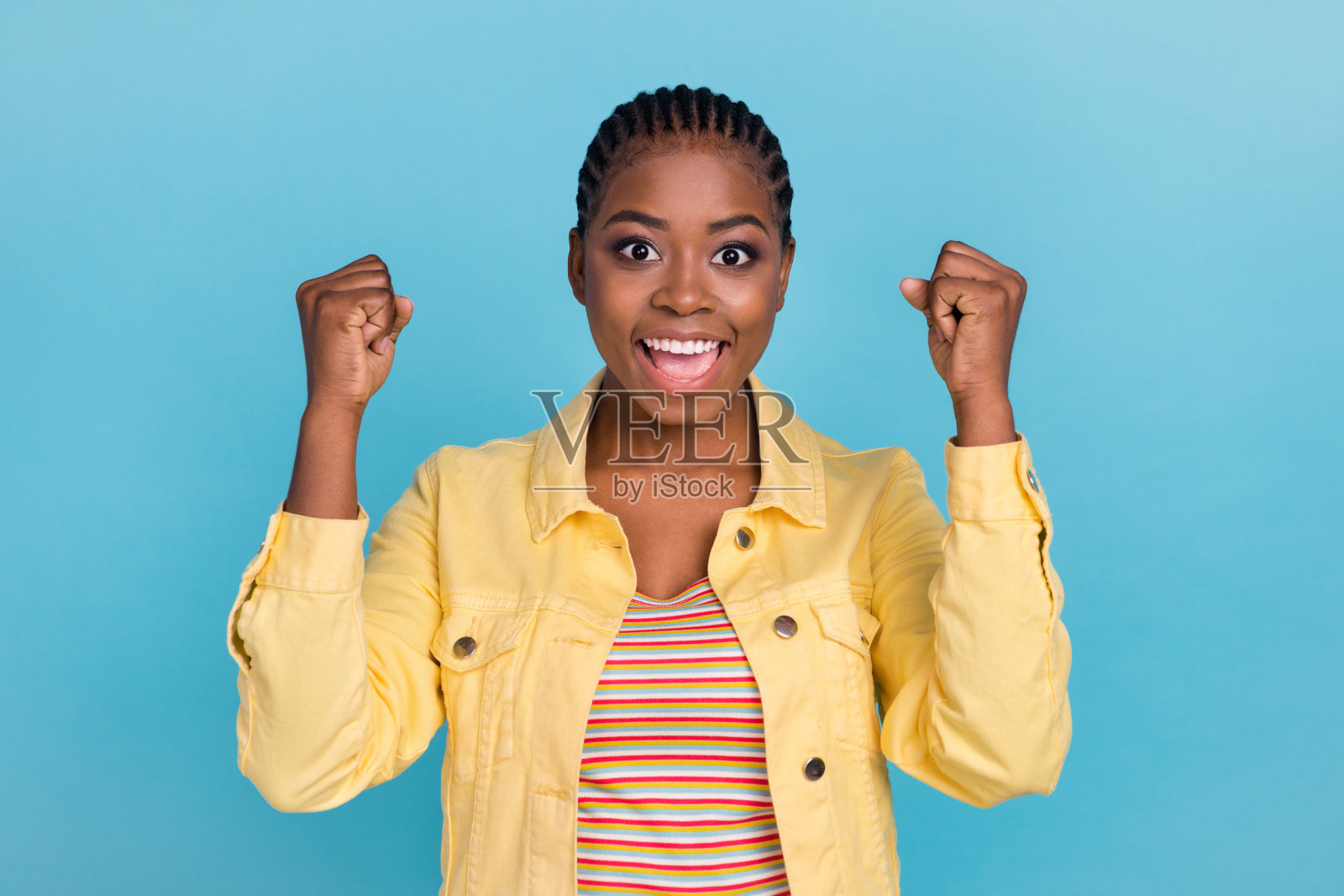 迷人的快乐女孩在明亮的蓝色背景下庆祝成功，享受乐趣。照片摄影图片