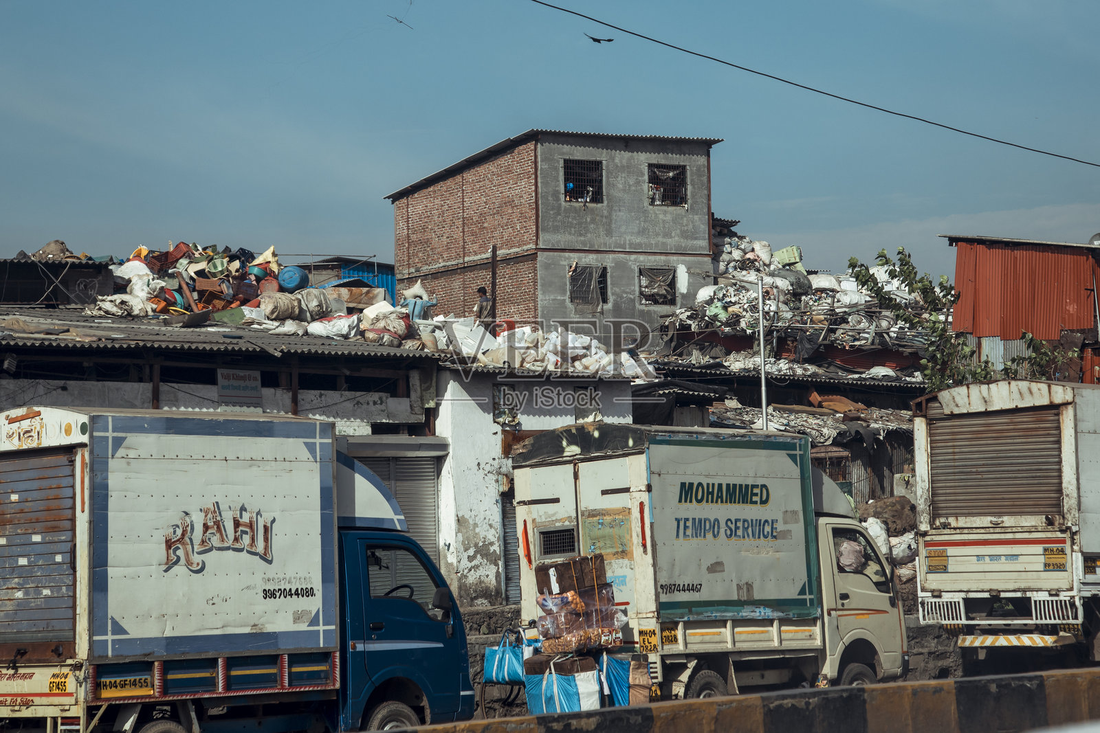 孟买达拉维贫民窟的卡车和垃圾在阳光明媚的日子里照片摄影图片