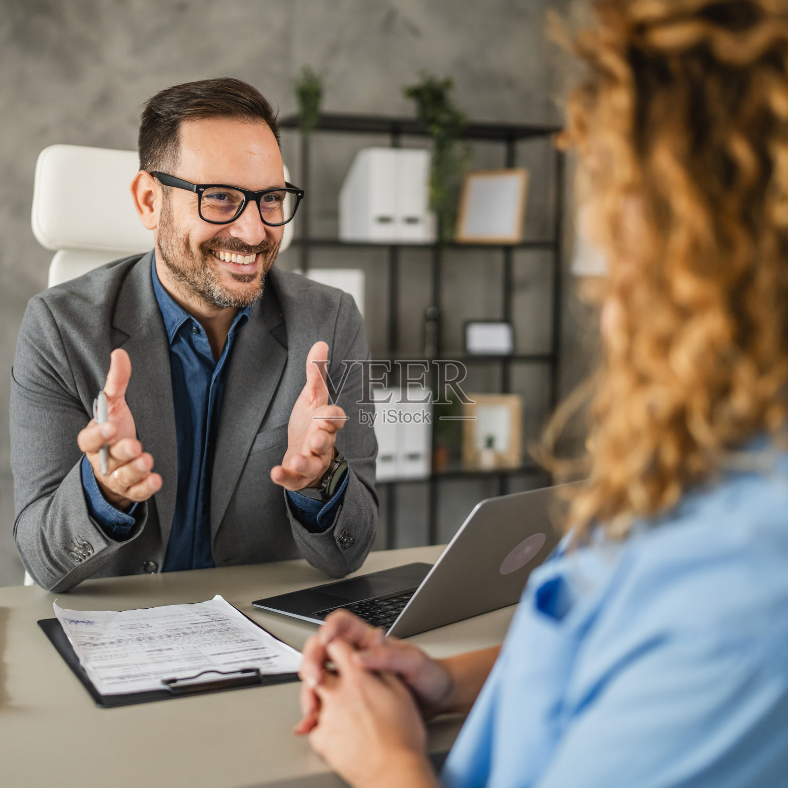 经理向成年女性解释并展示工作内容，进行面试。照片摄影图片