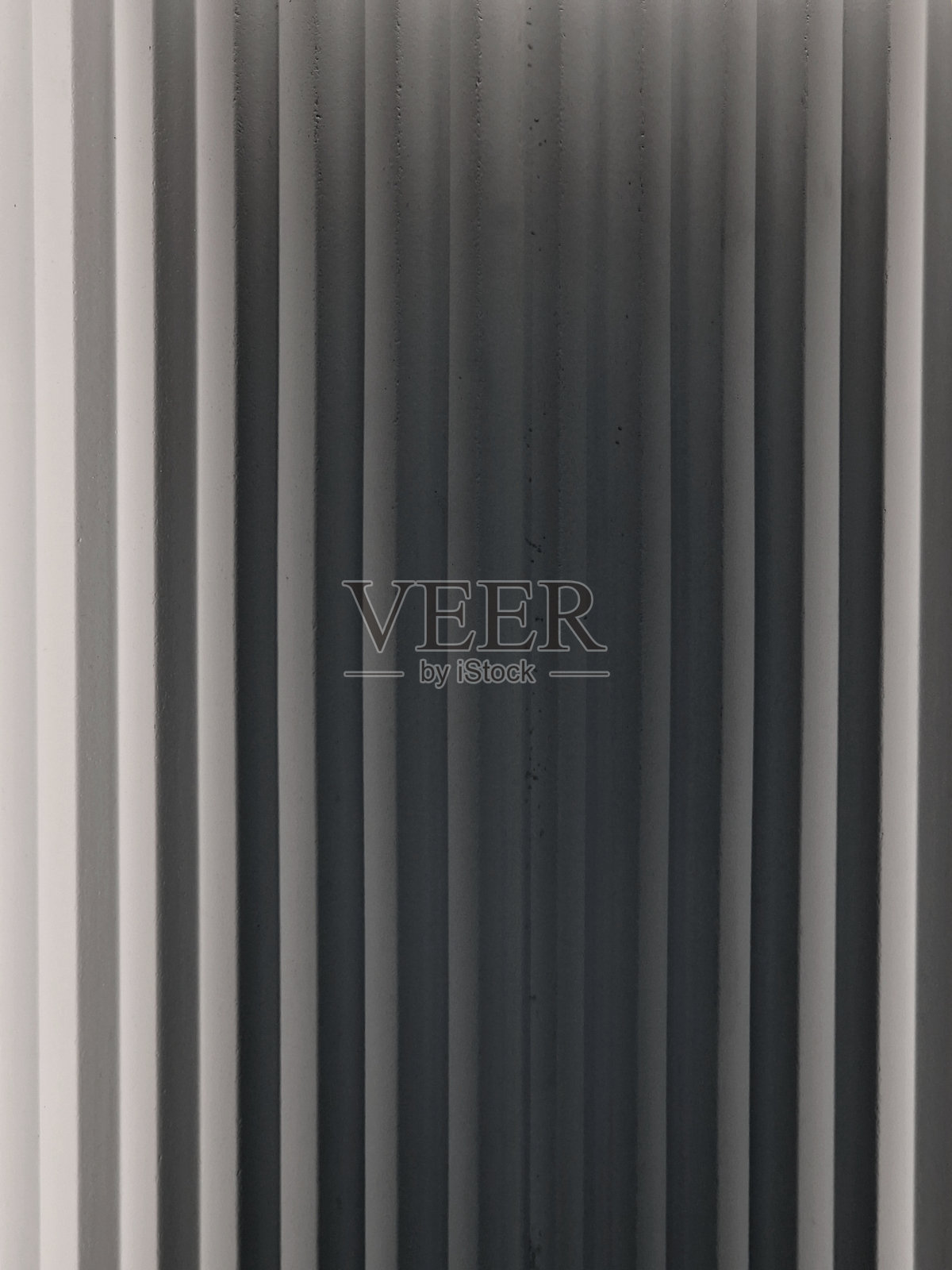 带有条纹的灰泥墙，仿佛折叠的布料，上面有叠加的三角形划痕，呈现出浮雕效果和明亮的阴影。照片摄影图片