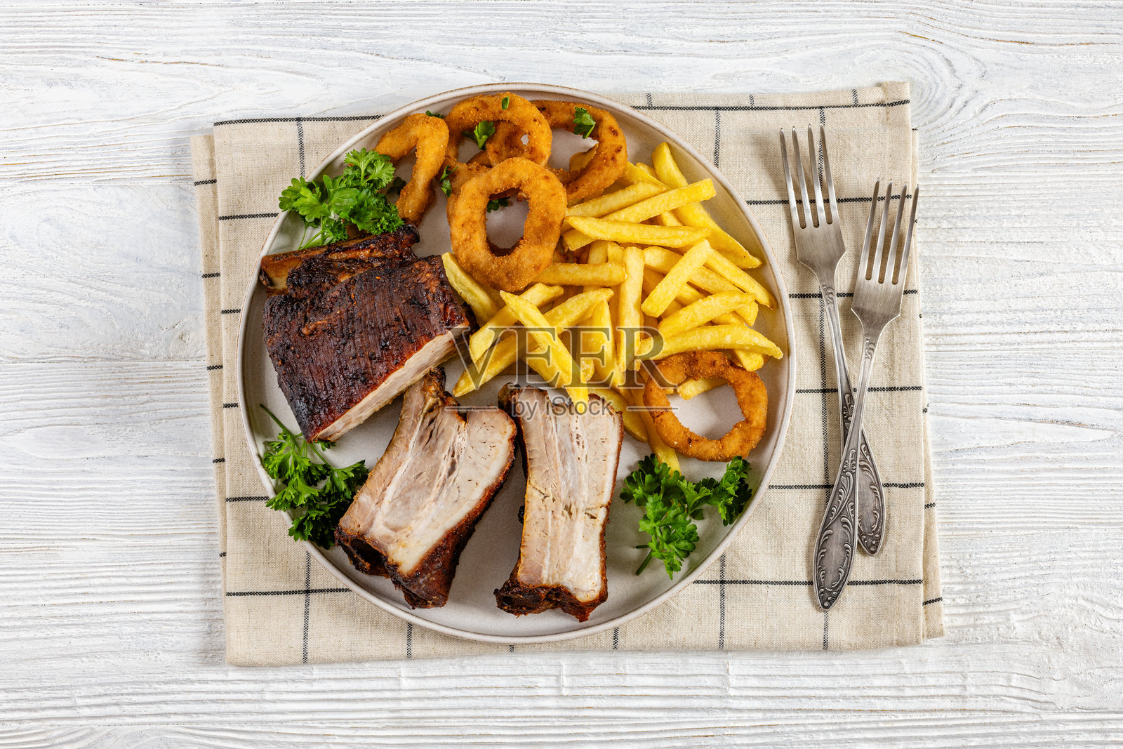 烤猪肋排配洋葱圈和薯条照片摄影图片