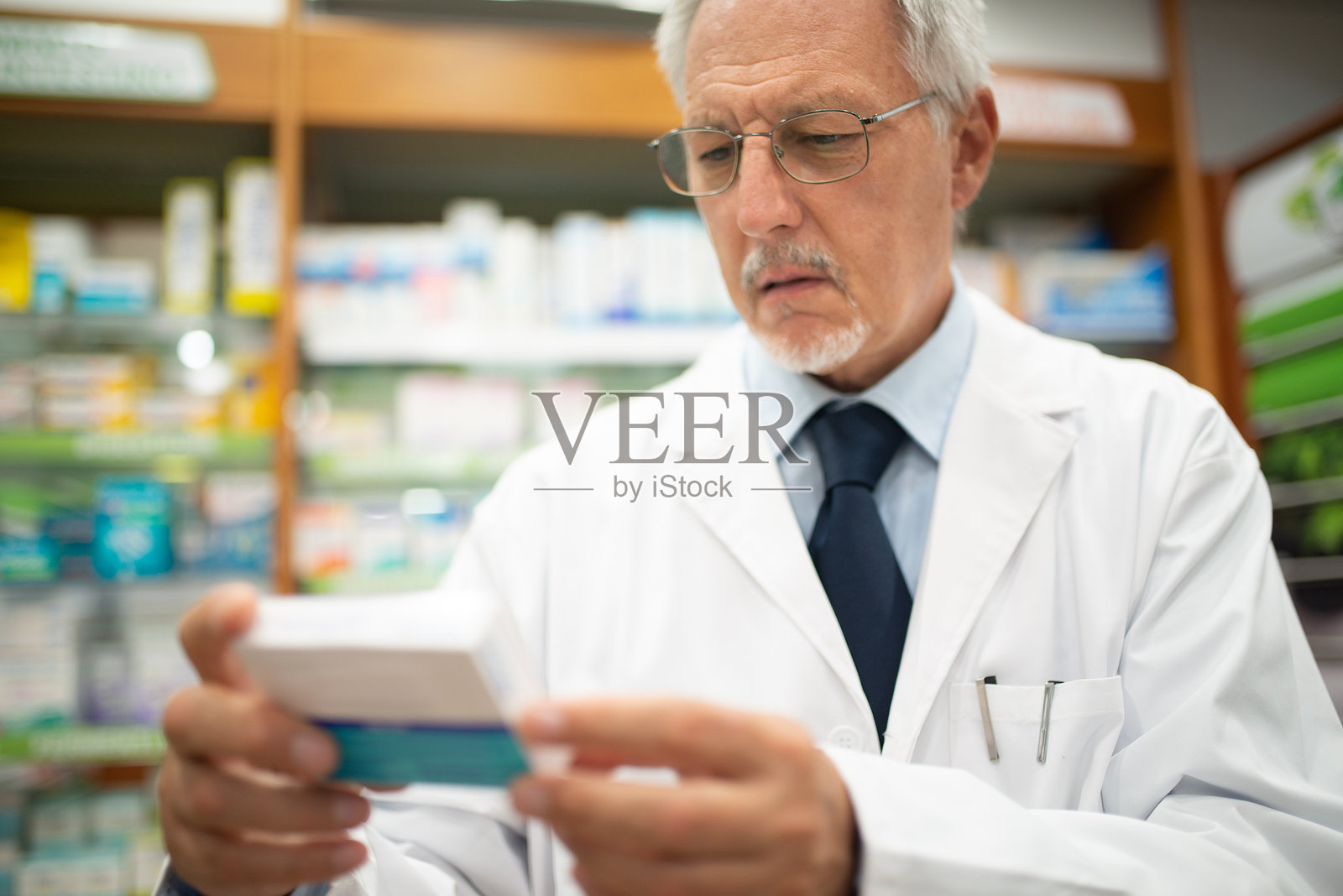资深药剂师在药房阅读药品盒子照片摄影图片