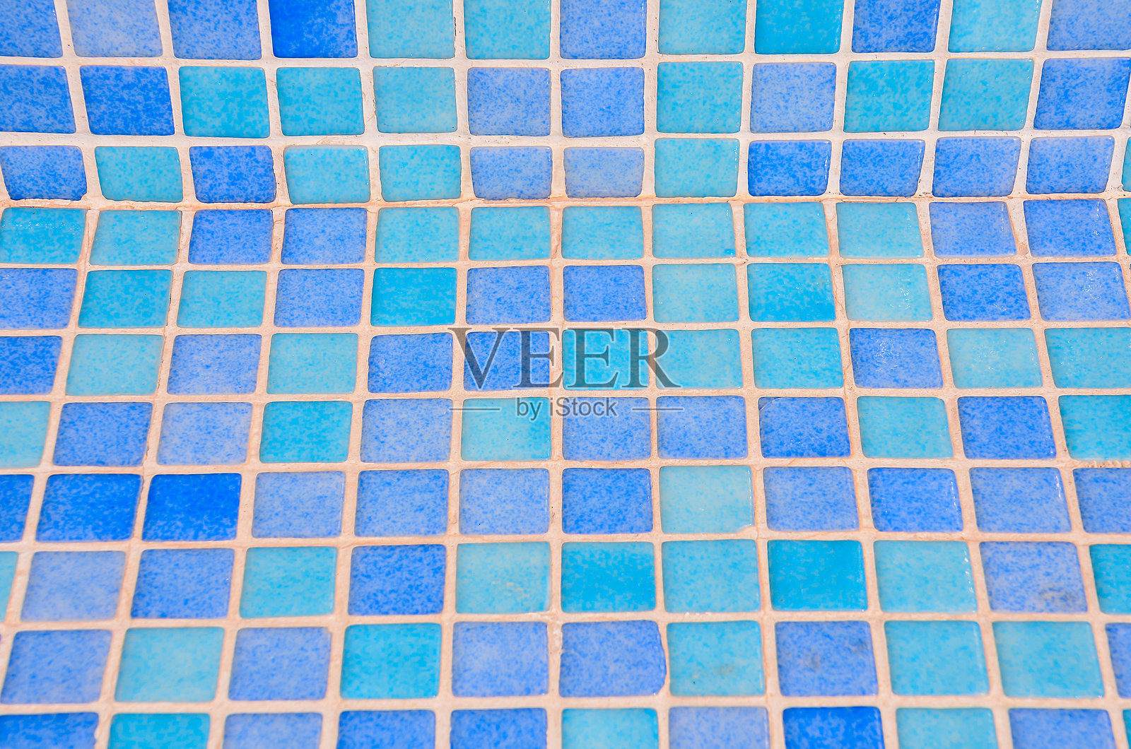 蓝白相间的瓷砖地板，中间有一块蓝色瓷砖。照片摄影图片