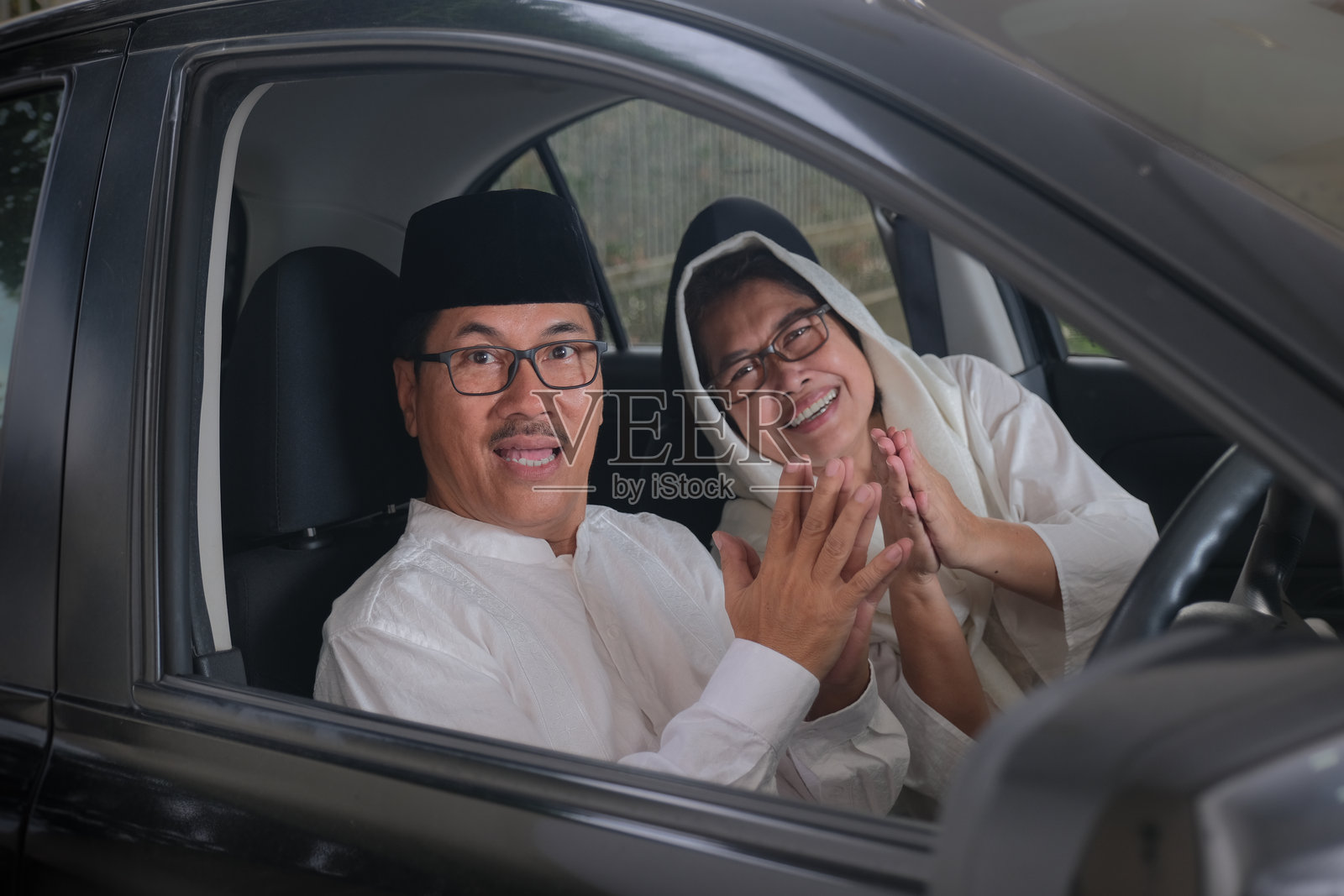 成年穆斯林男女在车厢内互相问候照片摄影图片