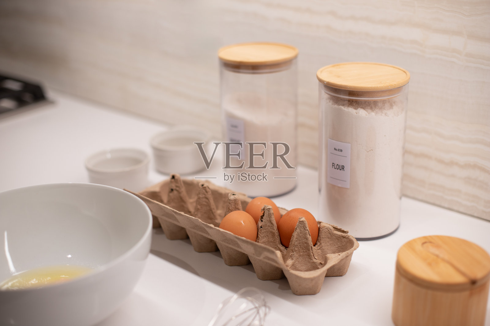 烹饪食材，早餐，逐步烹饪，鸡蛋，盘子，打蛋器，面粉，厨房桌上的烘焙材料。照片摄影图片