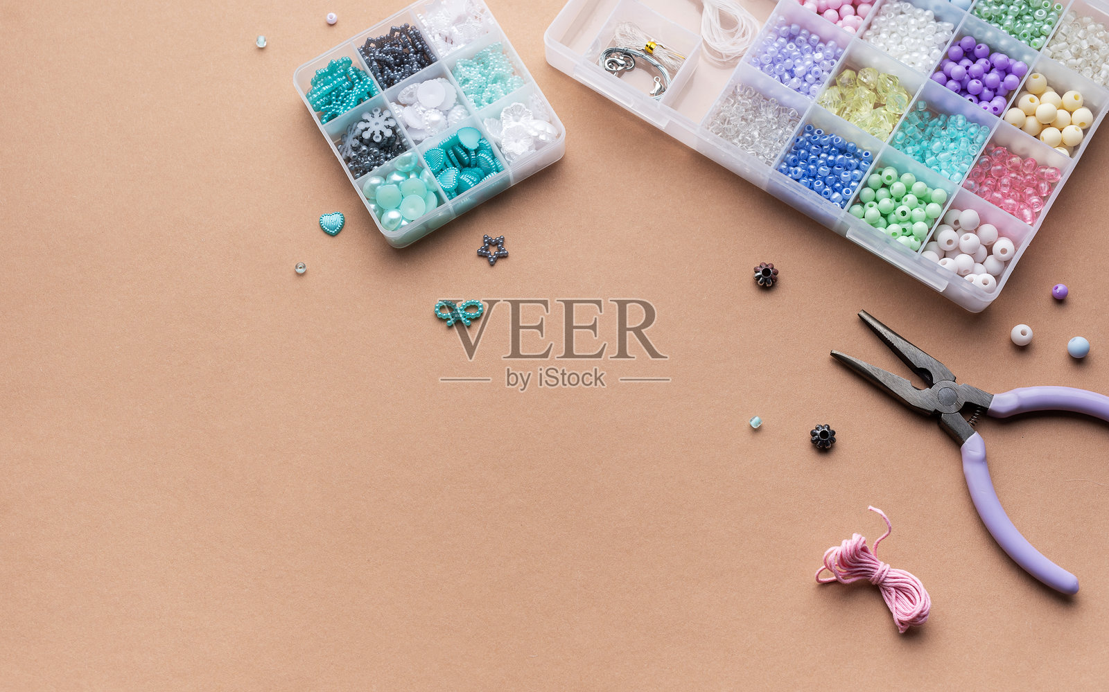 在明亮的阳光下，使用工具和容器在平坦的工作空间上制作五彩缤纷的珠子工艺品照片摄影图片