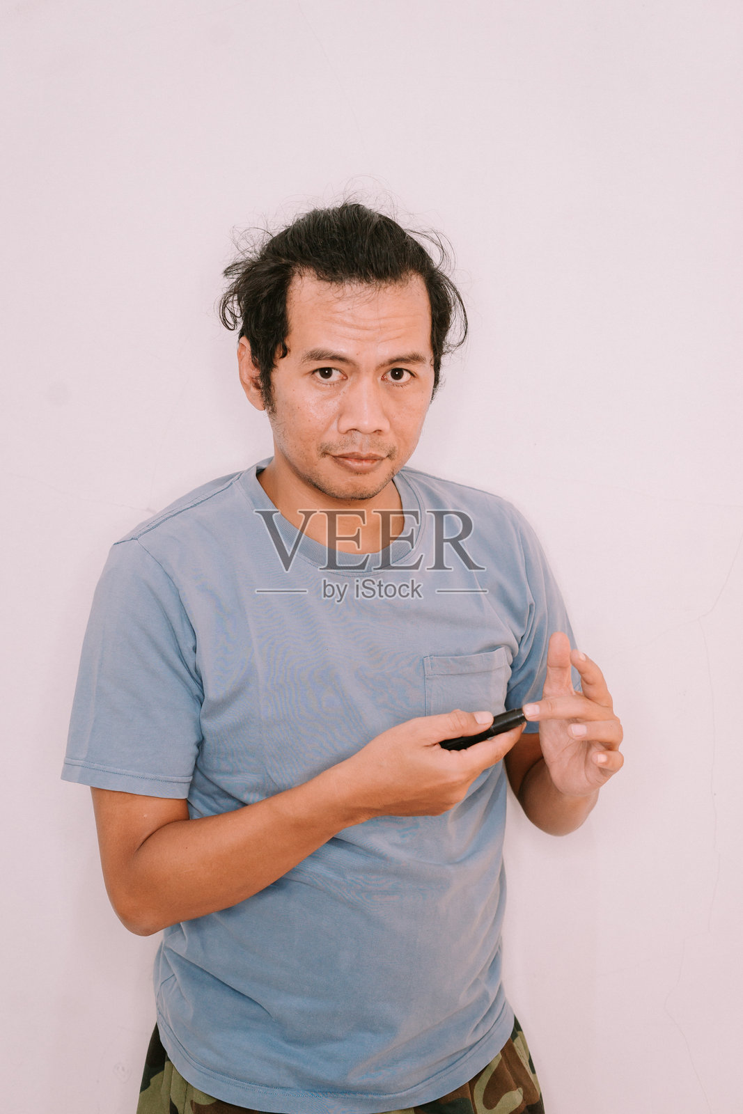 东南亚男子用糖尿病设备在手指上测试血糖照片摄影图片