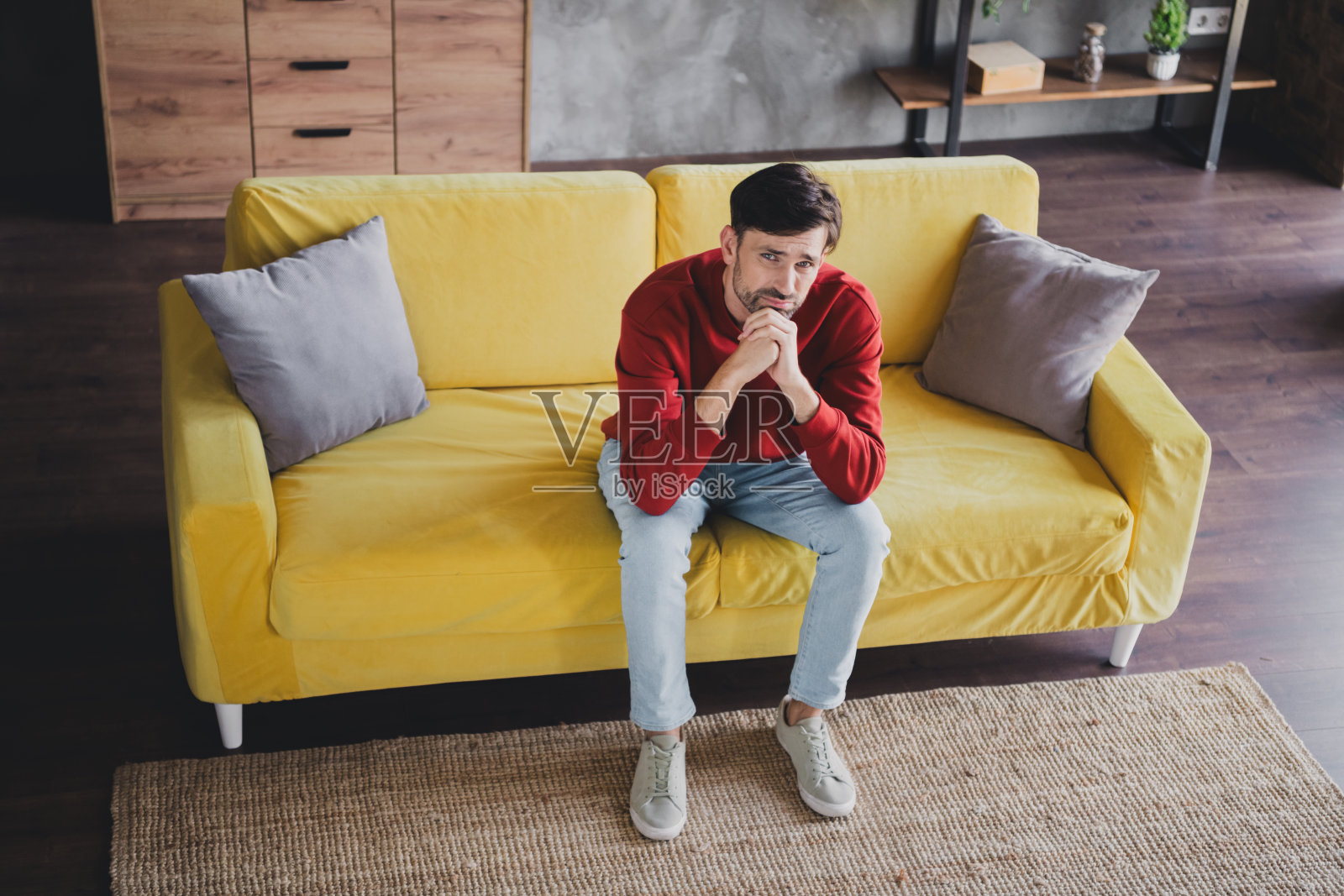 年轻帅气的男士在明亮的黄色沙发上享受轻松的周末时光照片摄影图片