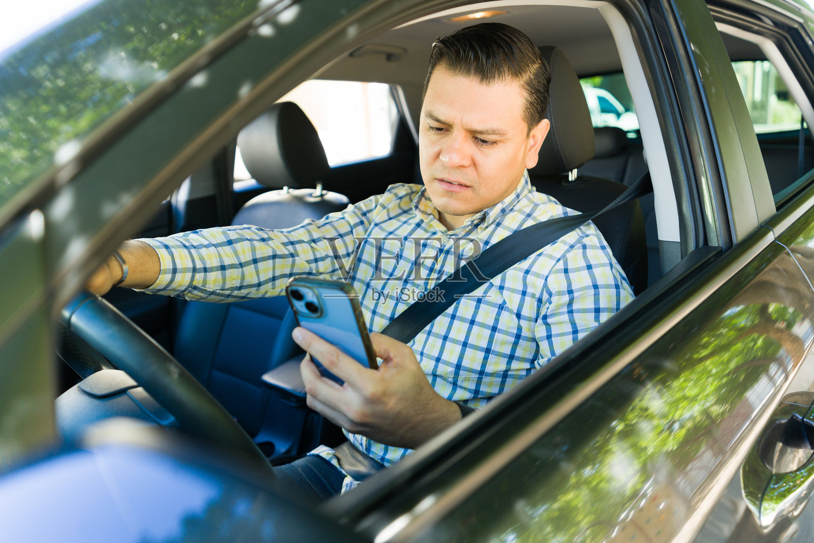 拉丁裔商人在开车时打电话，冒着发生事故的风险照片摄影图片