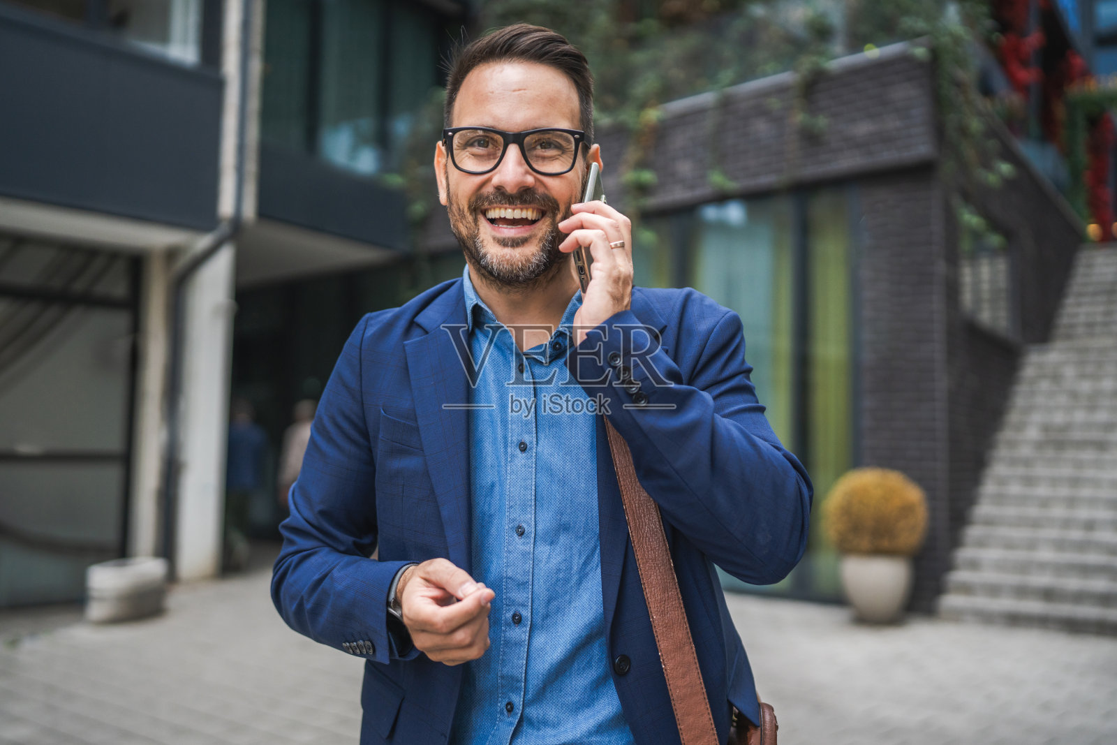 成年商人在城市中走动并打电话。照片摄影图片
