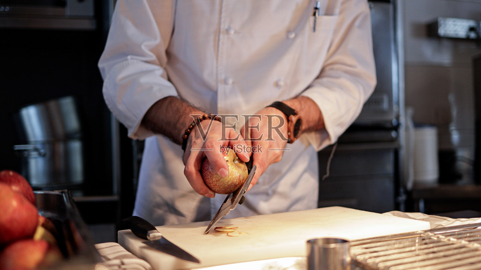 厨师在专业厨房中切割新鲜苹果，精确准备烹饪菜肴的食材照片摄影图片