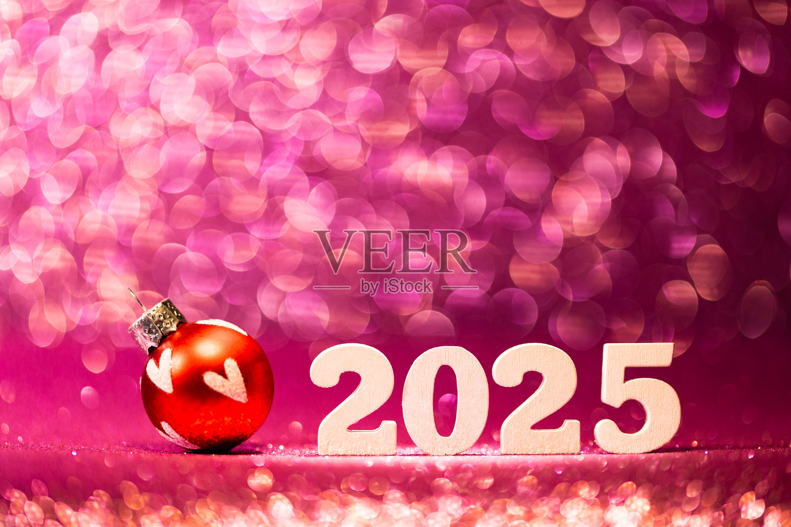 白色数字2025在粉红红色闪烁的散景背景上呈现，散发出神奇而节日的光辉。照片摄影图片