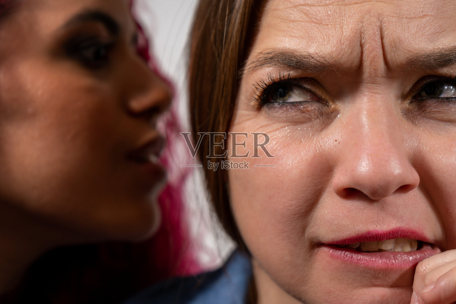 一个女人在她朋友耳边低声说坏消息照片摄影图片