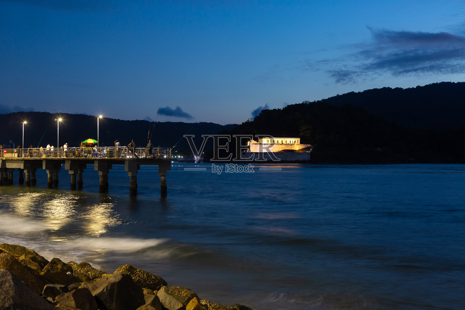 桑托斯市安德拉达斯堡的夜景，前景是渔民码头。照片摄影图片