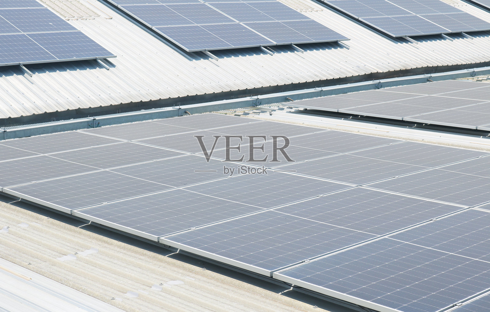 绿色建筑的并网太阳能屋顶面板系统。照片摄影图片